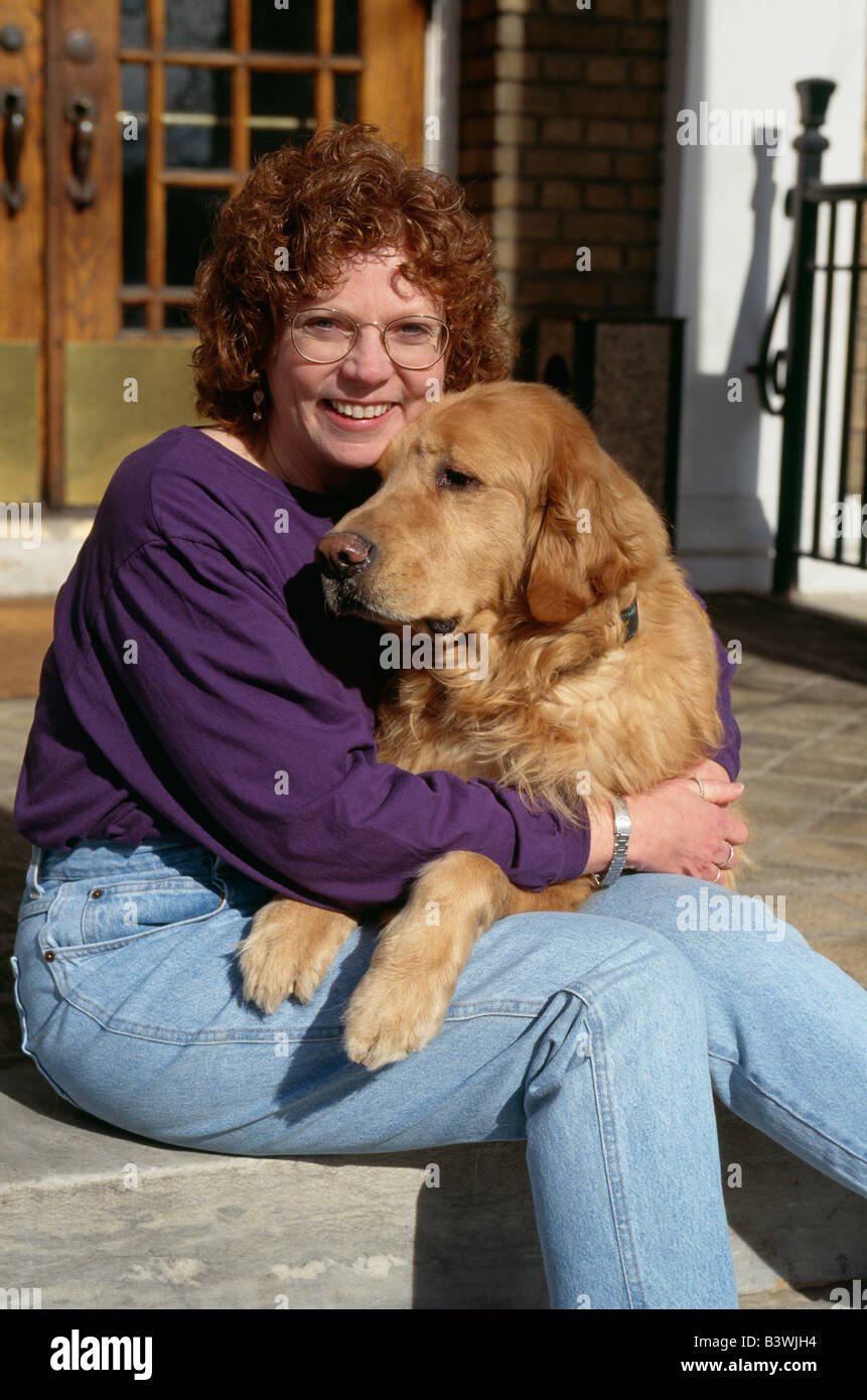 Porträt der mittlere gealterte Frau und ihrem Golden Retriever Hund.  Die Frau nimmt den Hund zu besuchen kranke Kinder als eine Form der Therapie Stockfoto