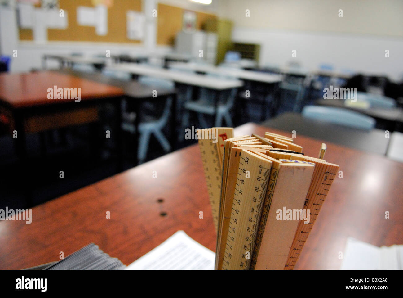 hölzerne Herrscher (Regeln) auf Schreibtisch im Klassenzimmer, keine Menschen Stockfoto