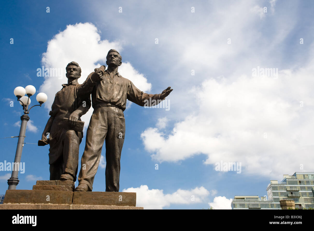 Zwei bronze Sozialrealismus Skulpturen Geste kühn vor Gebäuden und einem blauen Himmel in Vilnius Litauen über die Grüne Brücke. Stockfoto