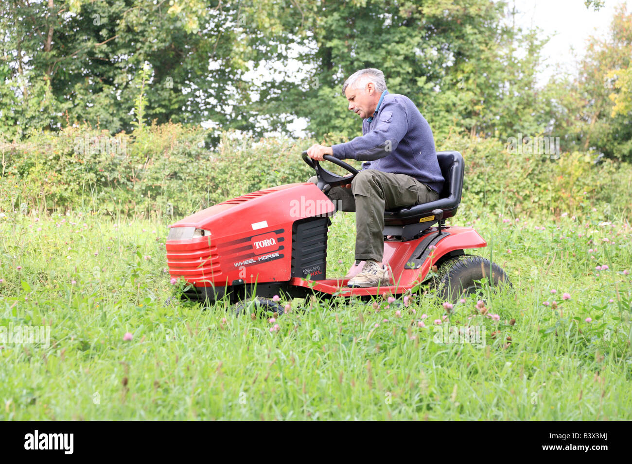 Rasenmähen auf Reitenauf Rasenmäher Mann Stockfotografie Alamy