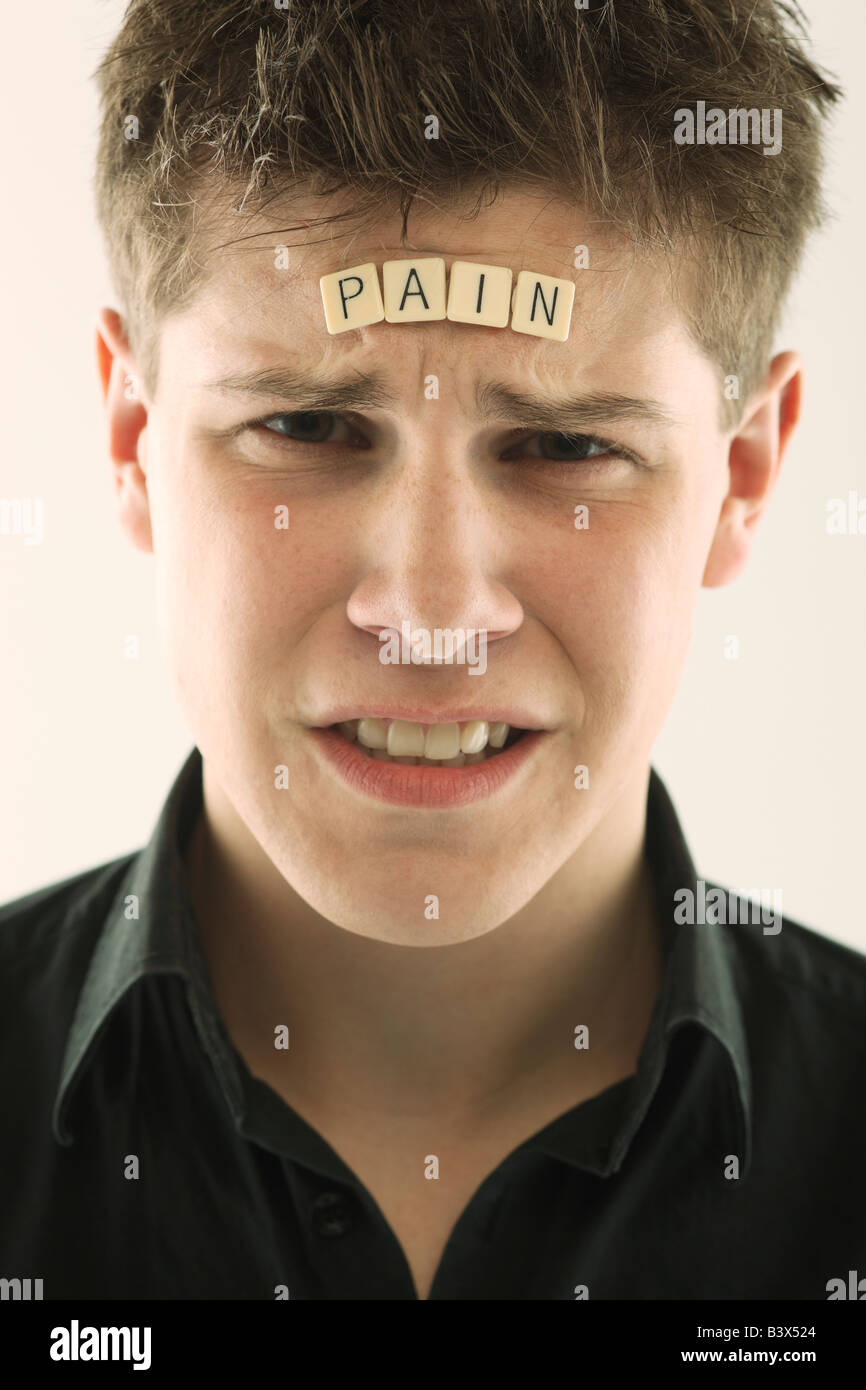 Mann mit dem Wort "Schmerz" mit Buchstabensteine auf seinem Kopf geschrieben Stockfoto