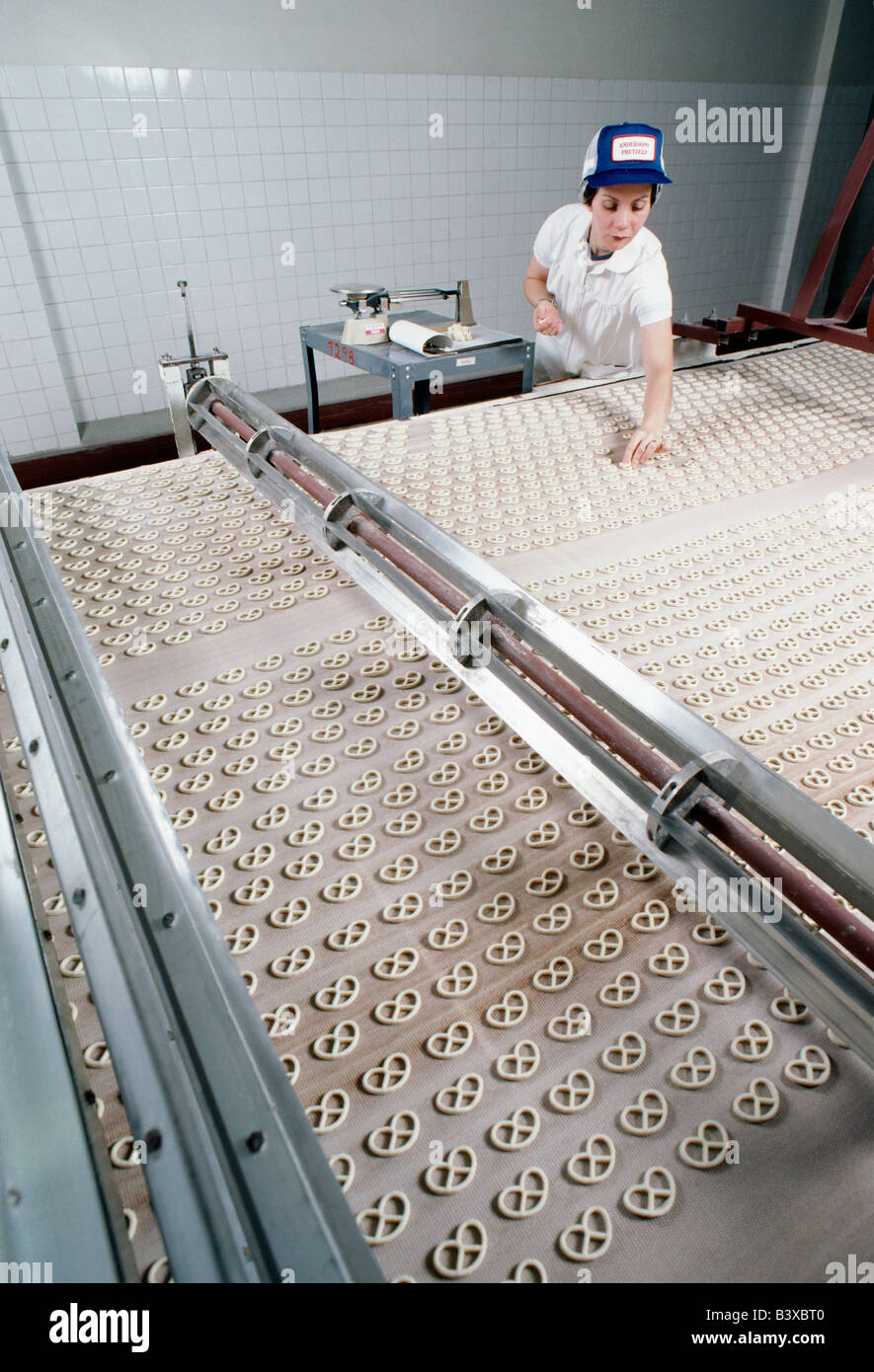 Arbeitnehmerin prüft Brezeln auf der Produktionslinie bei Andersons Brezel Company in Lancaster, Pennsylvania, USA Stockfoto