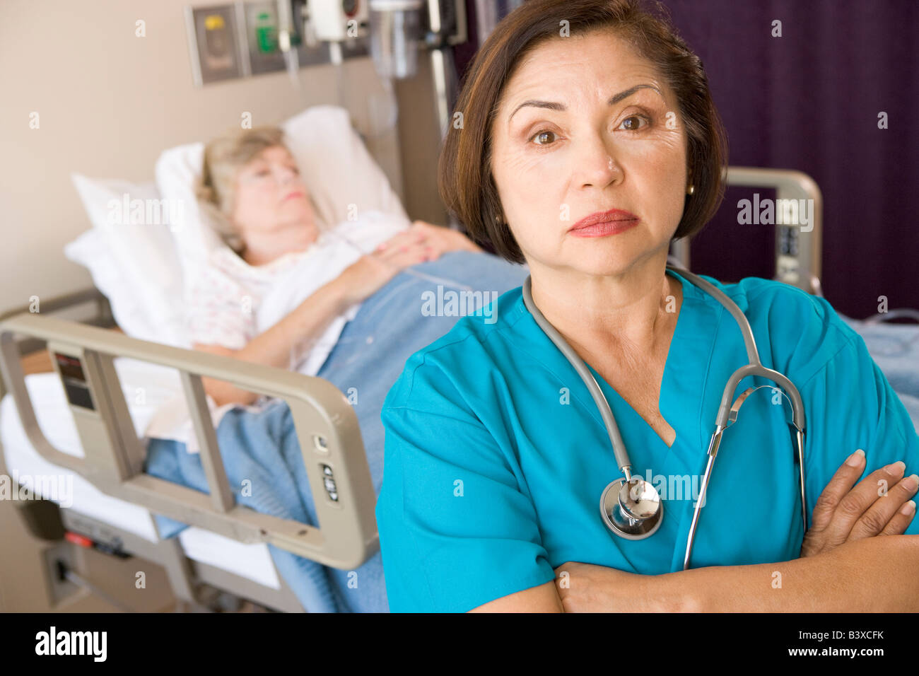 Arzt steht mit verschränkten im Patienten-Zimmer Stockfoto