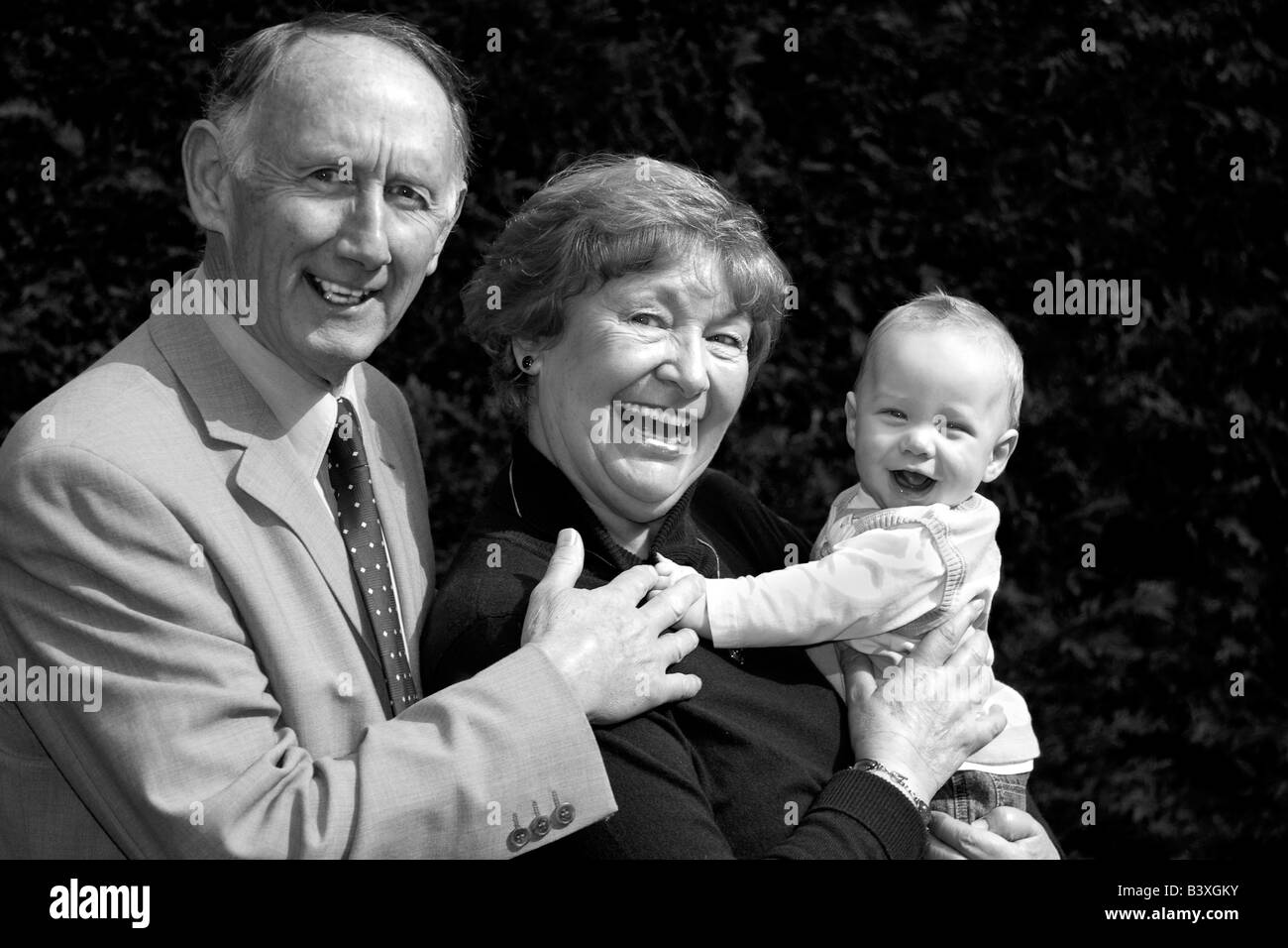 Lächelnde Großeltern halten glückliches Baby Boy Porträt Stockfoto