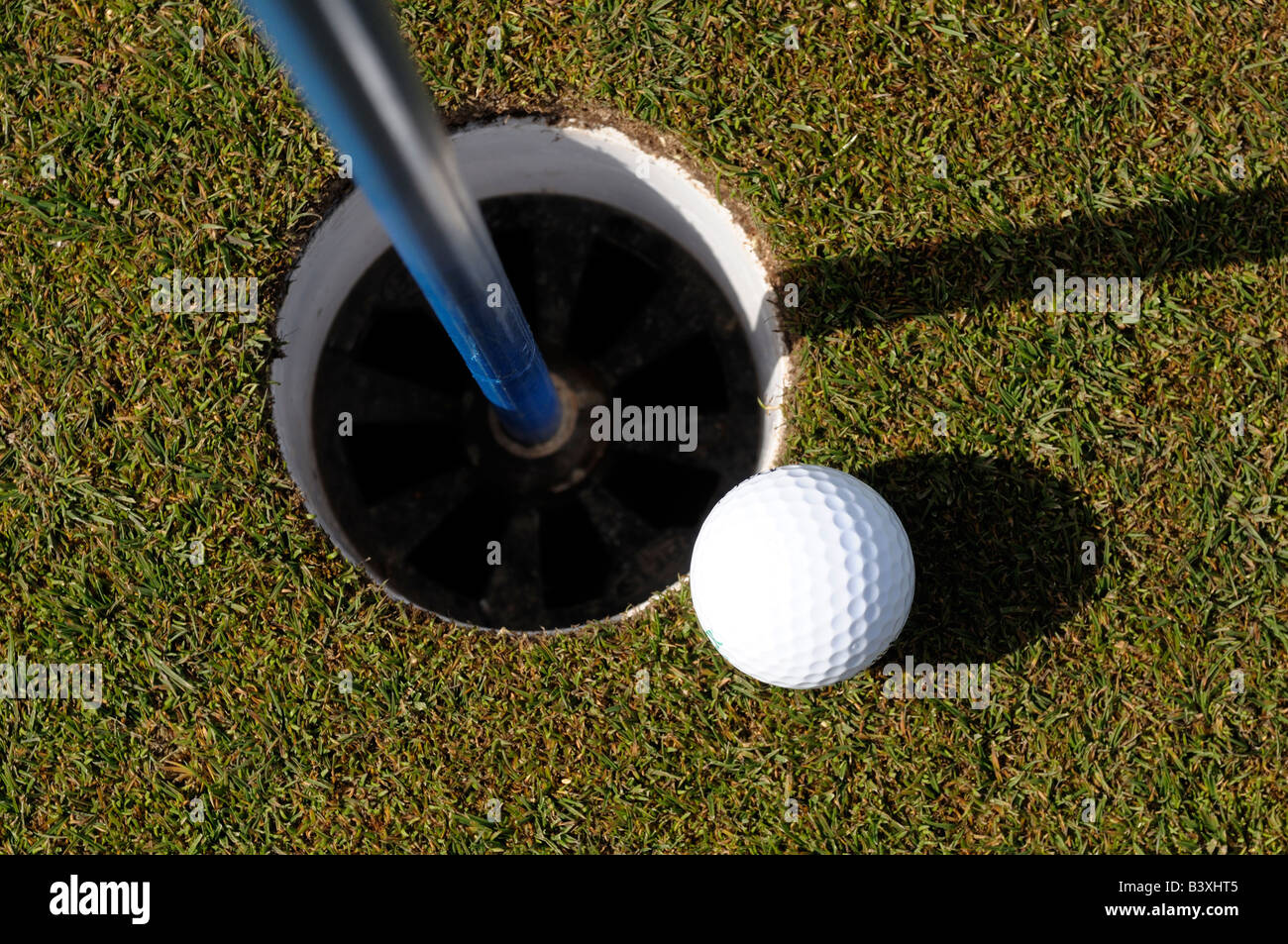 Golfball und Loch Stockfoto