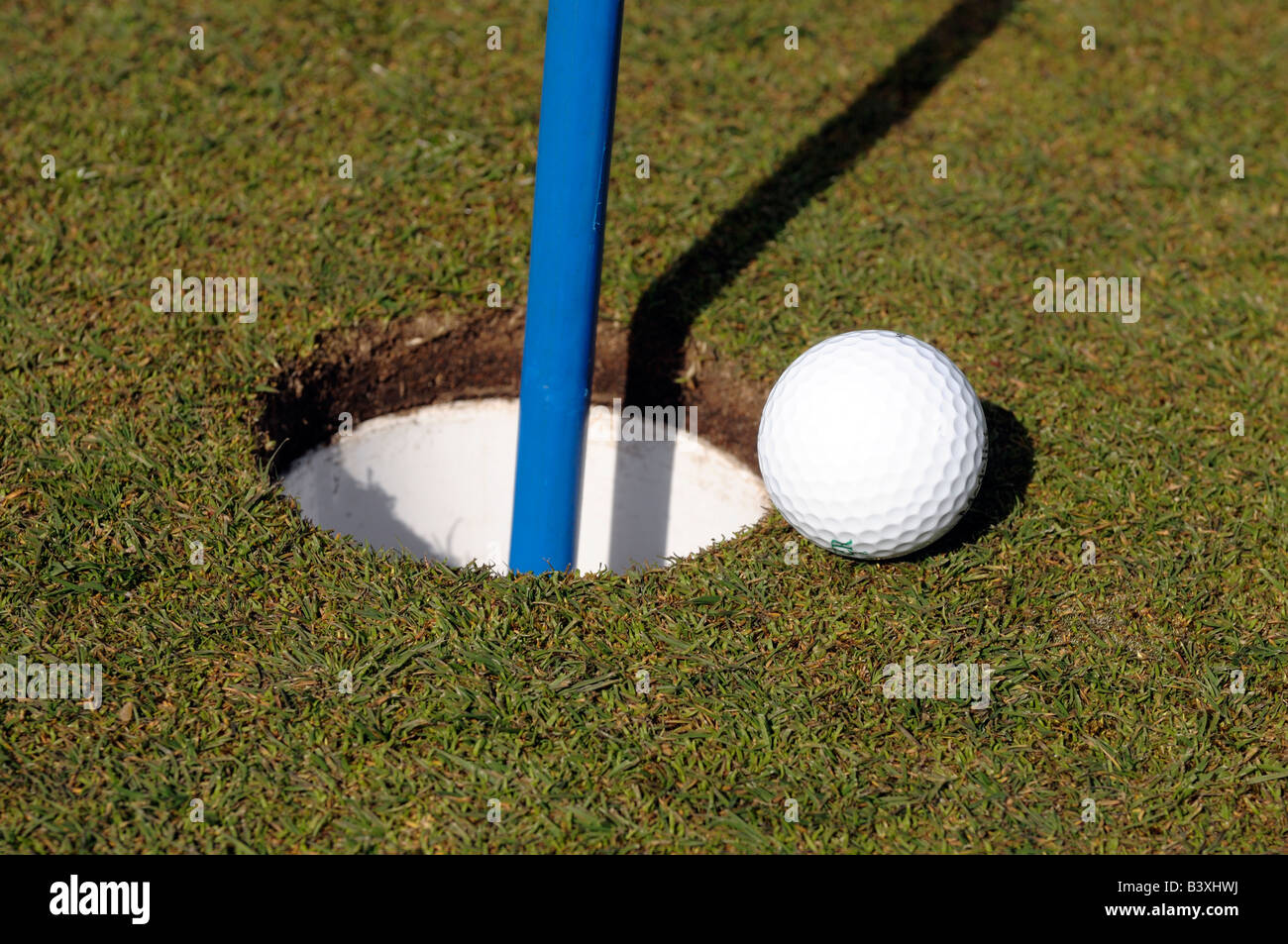 Golfball und Loch Stockfoto