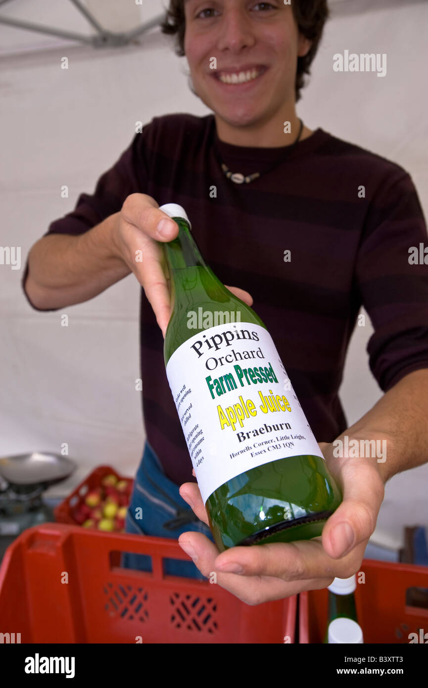 Lächelnde Verkäufer bietet frisch gepresst Apfelsaft Acton Food Festival Acton W3 London Vereinigtes Königreich Stockfoto