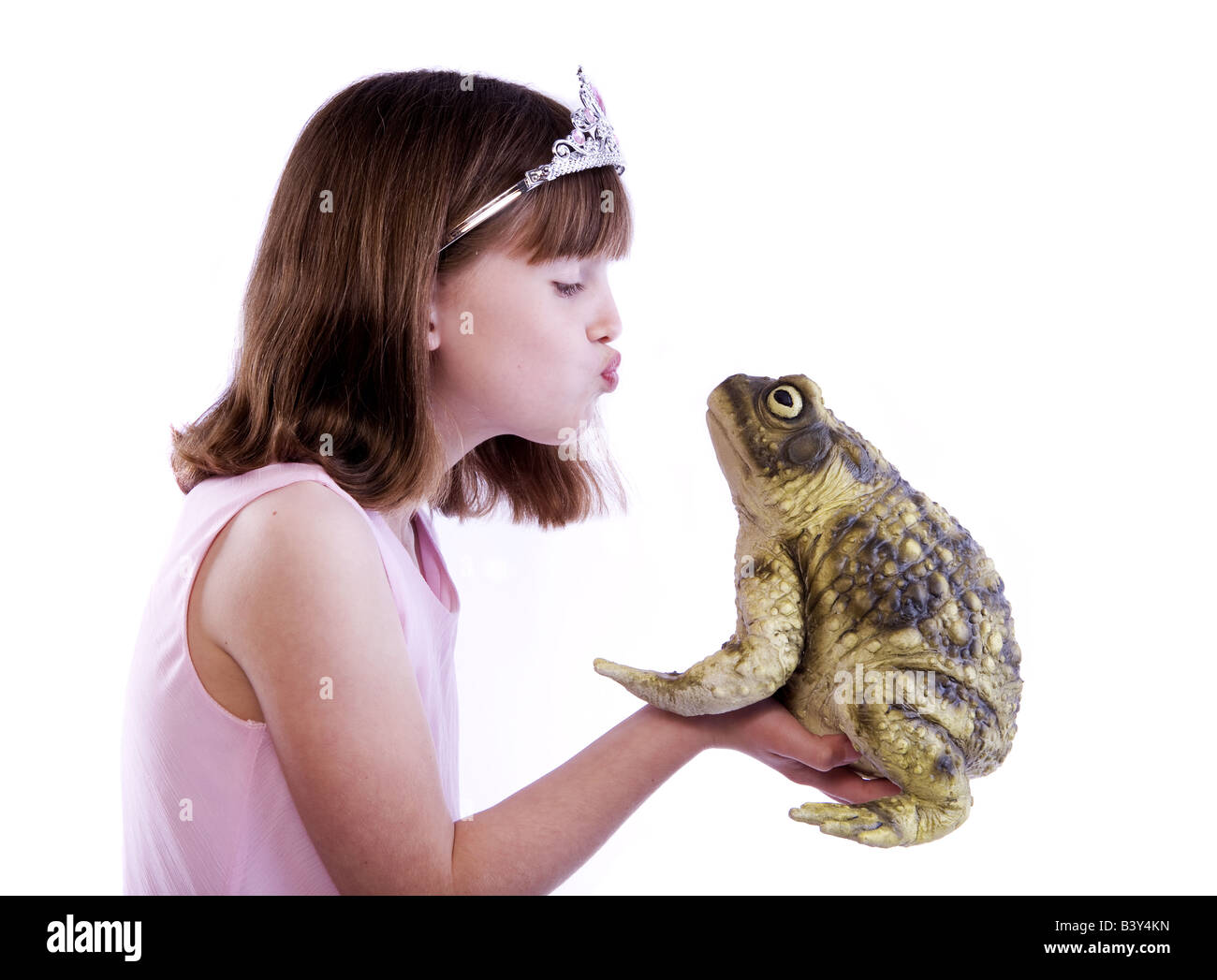 Junge Mädchen wie eine Prinzessin mit Kröte oder Frosch gab es einen Kuss isoliert auf weißem Hintergrund Stockfoto