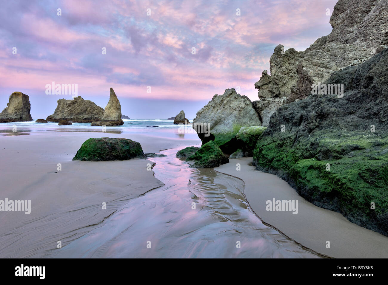 Sonnenaufgang am Strand mit kleinen Bach an Bandon, Oregon Stockfoto