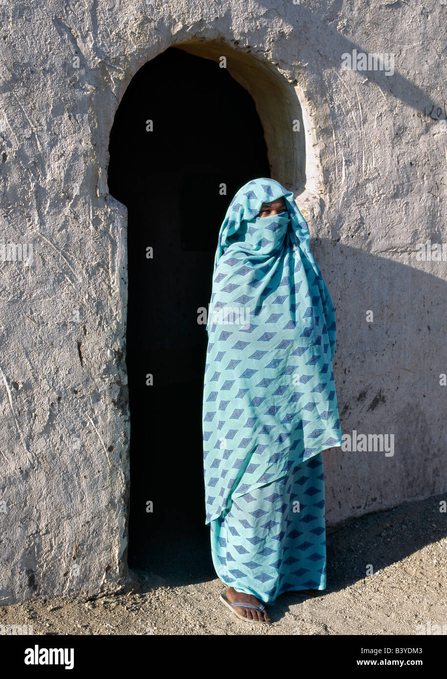Sudan, Nil, 4. Katarakt. Außerhalb der Veranda ihres Hauses steht eine nubische Frau, ihr Gesicht bedeckt von dem Kopftuch, ihren muslimischen Glauben zu bezeichnen. Der Stil der Veranda Bogen ist typisch für die nubischen Menschen. Das Dorf sie auf dem Nil, in der Nähe von Shaallal Arraabia oder der 4. Katarakt lebt wird im Jahr 2008 überflutet werden, ein riesiger arabischen finanzierter, Chinesen gebaut, hydroelektrischer Damm abgeschlossen sein wird. Bereits haben einige Dörfer auf bewässertem Land weit weg verlegt. Stockfoto