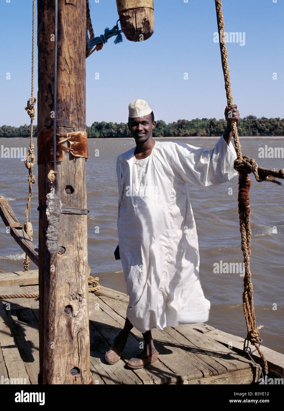 Sudan, Delgo. Eine nubische Bootsmann auf seine Feluke, einem hölzernen Segelboot, die das Wasser des Nils in Ägypten und Sudan lagen. Stockfoto