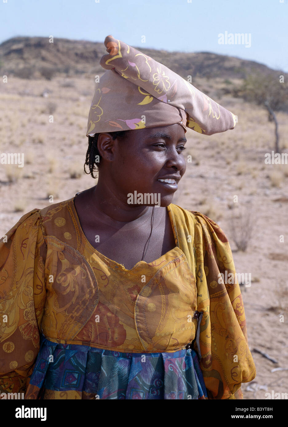 Namibia, Damaraland, Palmwag. Eine Herero-Frau. Die Ursprünge ihrer aufwendigen Kleid und einzigartigen Hut Stil geht zurück zu 19. Jahrhundert deutsche Missionare, die Ausnahme, was sie eine unbescheidene Form von Kleid unter dem Stamm als nahm. Sie bestand darauf, dass die Herero Frauen ihre eigenen unpraktisch Stil der viktorianischen Kleider anzunehmen. Im Laufe der Jahre entstanden bunte Kleidern der Herero als enorme Krinolinen über fünf Unterröcken getragen. Stockfoto