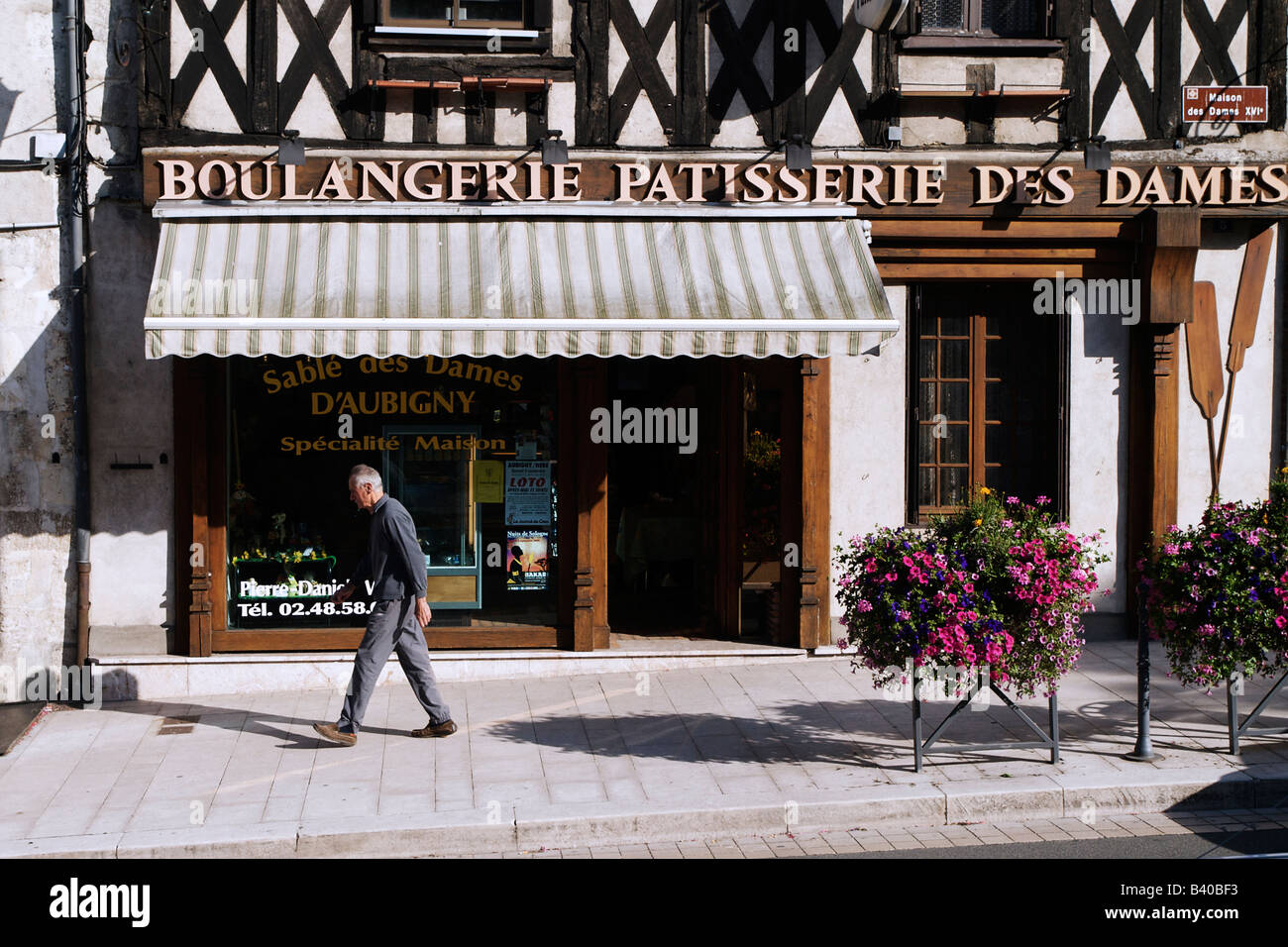 Ein Mann zu Fuß vor einer Boulangerie in Aubigny Frankreich Stockfoto