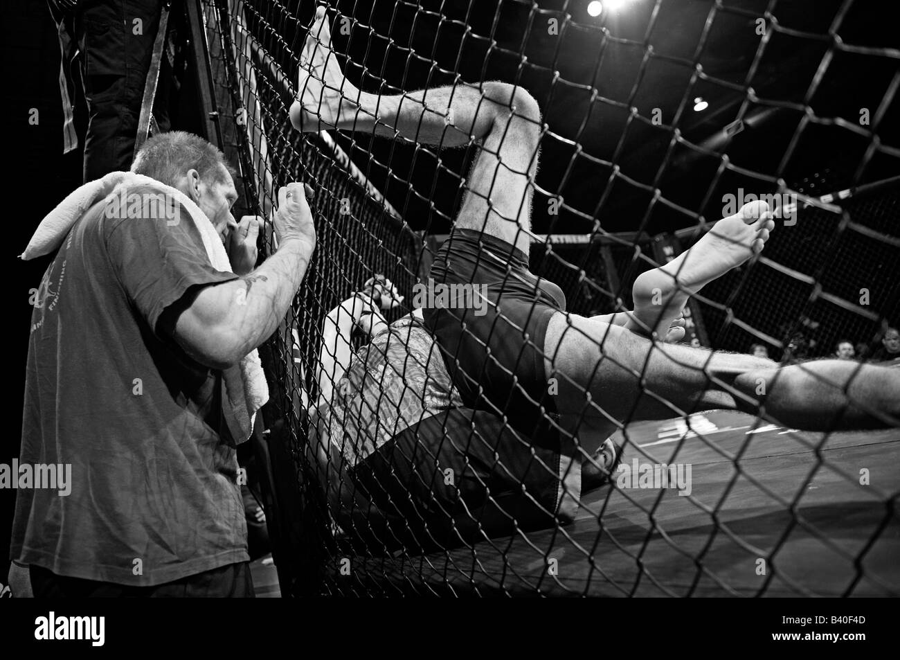 Zwei Käfig-Kämpfer kämpfen in Seite Octagon (Cage) Trainer Uhren auf. Stockfoto