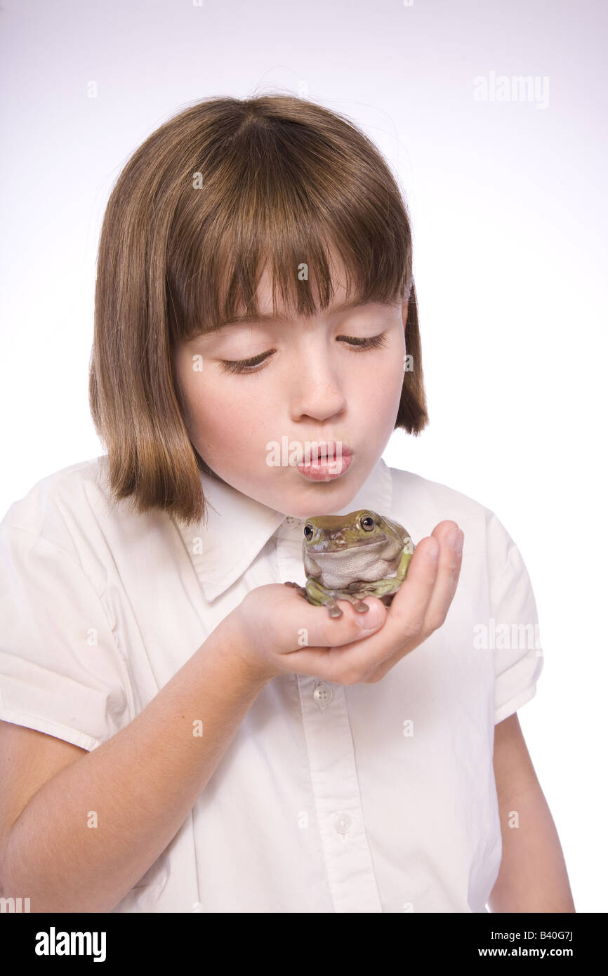 Junges Mädchen hält Kröte oder Frosch gab es einen Kuss isoliert auf weißem Hintergrund Stockfoto