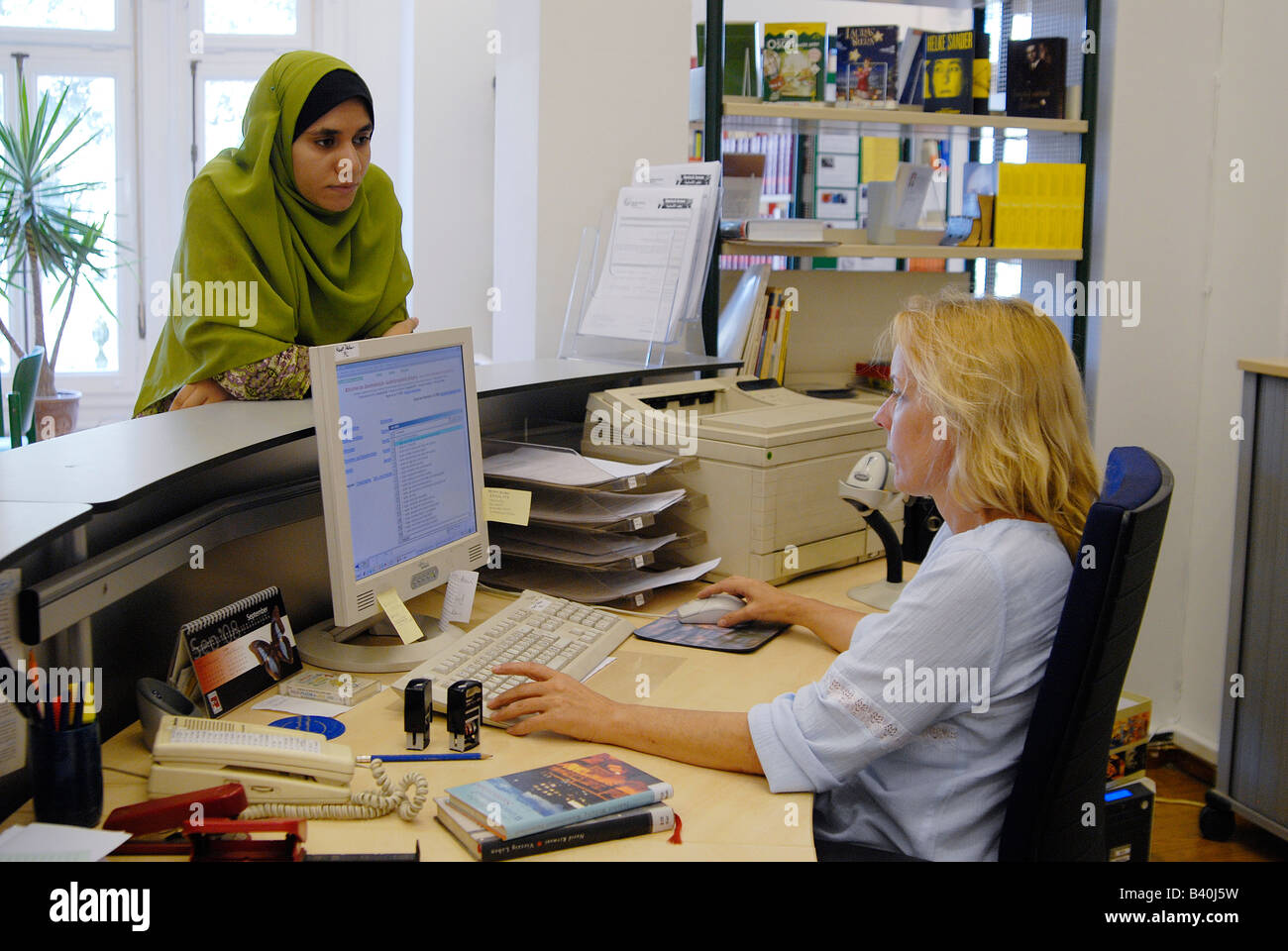 Ein junger ägyptischer Student bittet über ein Buch in einer deutschen Bibliothek in Kairo. Stockfoto