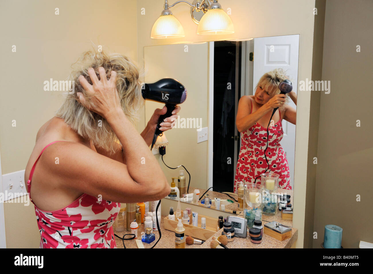 Erwachsene Frau föhnen Haare nach dem Duschen Stockfoto