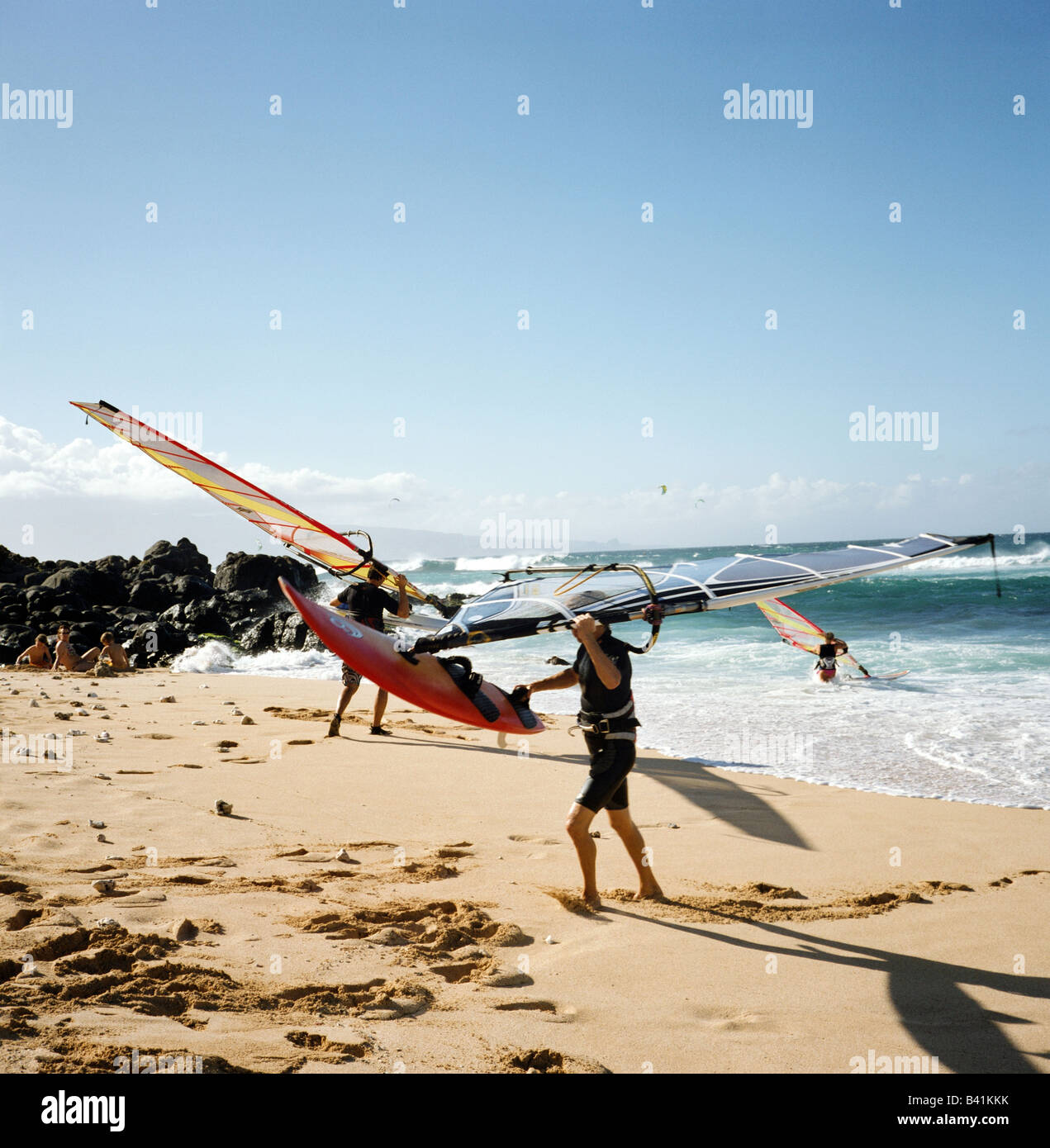 Windsurfer zu verlassen und ins Wasser in Ho'Okipa Beach, Maui, Hawaii. Stockfoto Windsurfer zu verlassen und ins Wasser in Ho'Okipa Beach, Maui, Hawaii. Stockfoto
