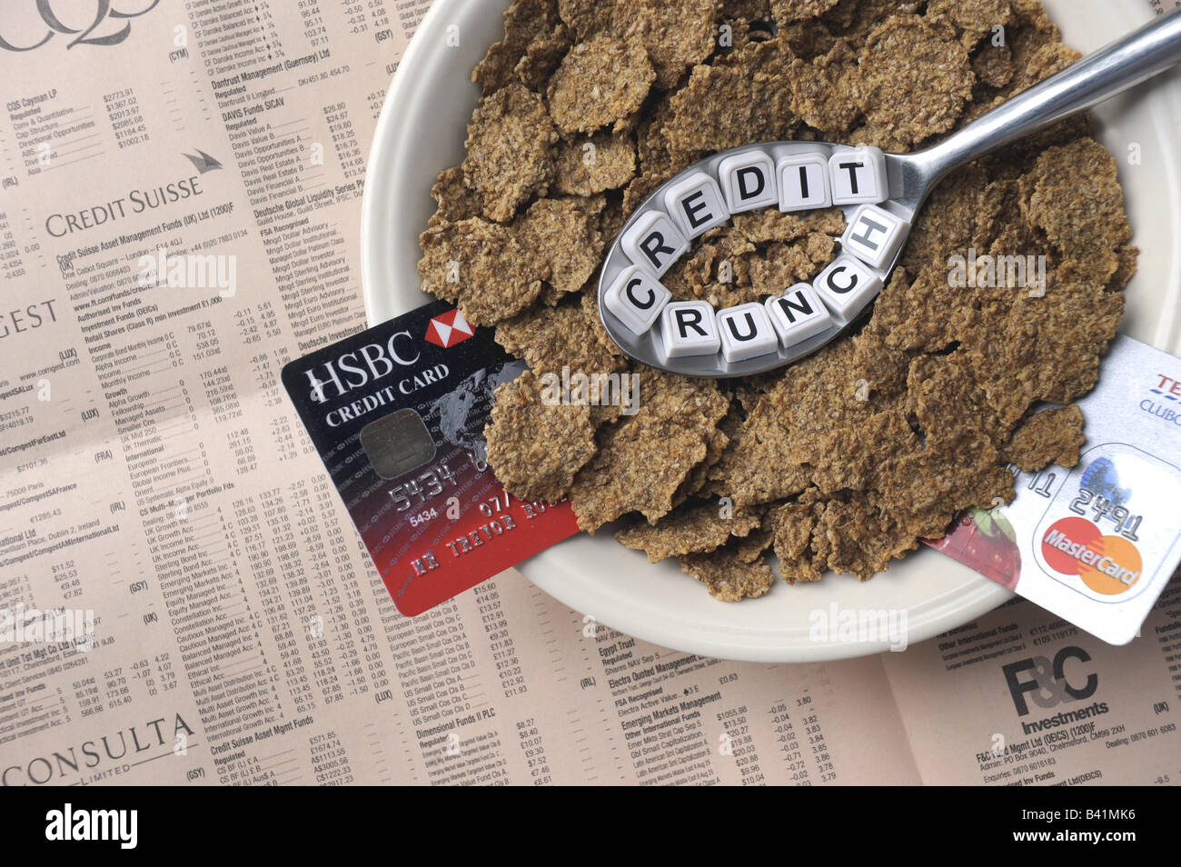 EIN LÖFFEL "KREDITKLEMME" FRÜHSTÜCKS-CEREALIEN MIT KOPIE DES FINANZIELLEN PAPIER UND KREDITKARTEN VERTRETUNG FINANZIELLE KRISE, UK... Stockfoto