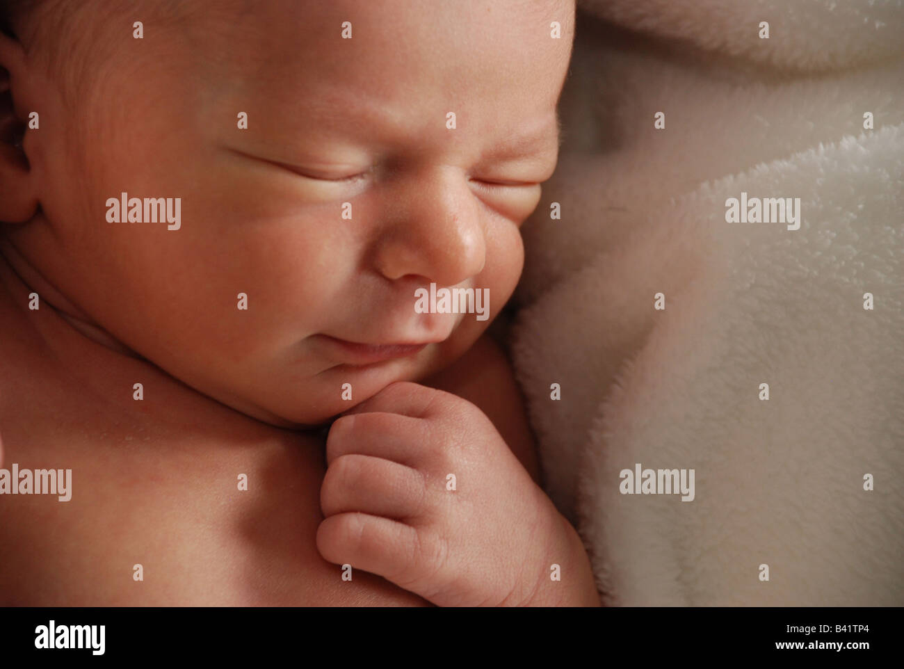 Ein Upclose Blick auf dem Gesicht eine Woche alten Baby. Das Neugeborene hat einen Hauch von einem Lächeln auf seinem Gesicht. Neutrale Farben. Horizontale. Stockfoto