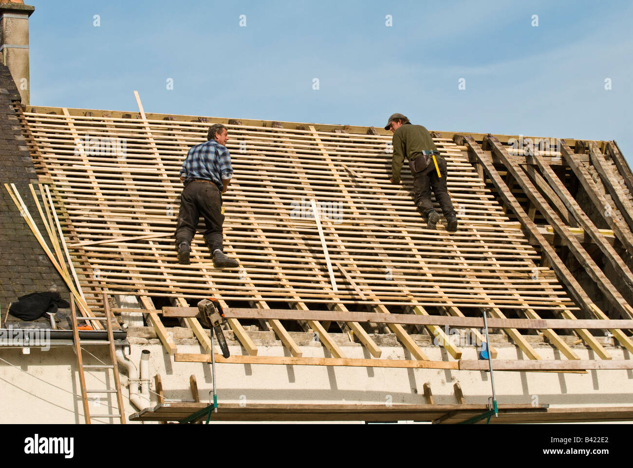 Bauarbeiter arbeiten auf Hausdach, Frankreich. Stockfoto