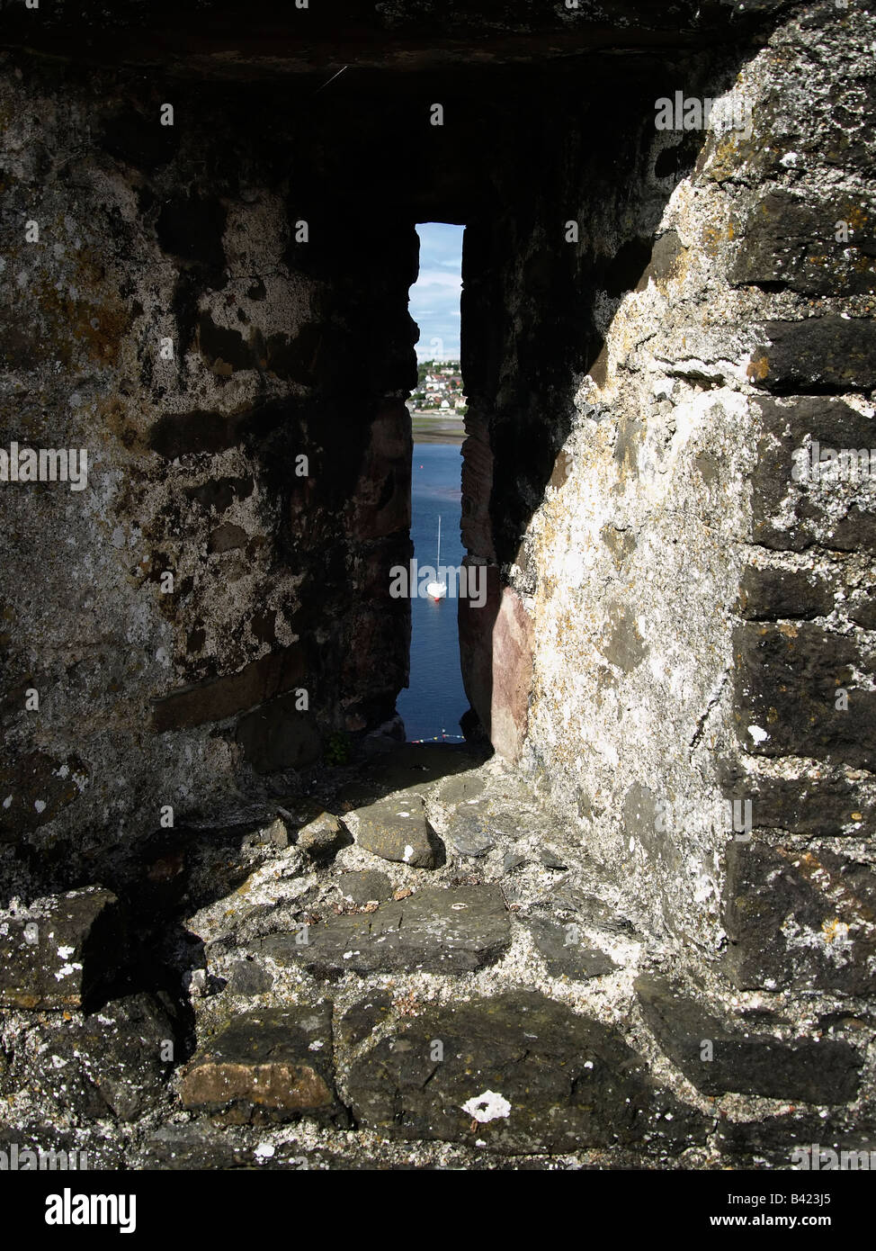 Pfeil-Schlitz mit Blick auf einer Yacht auf dem Fluss Conwy. Conwy Castle, ein UNESCO-Welterbe. Wales, UK Stockfoto