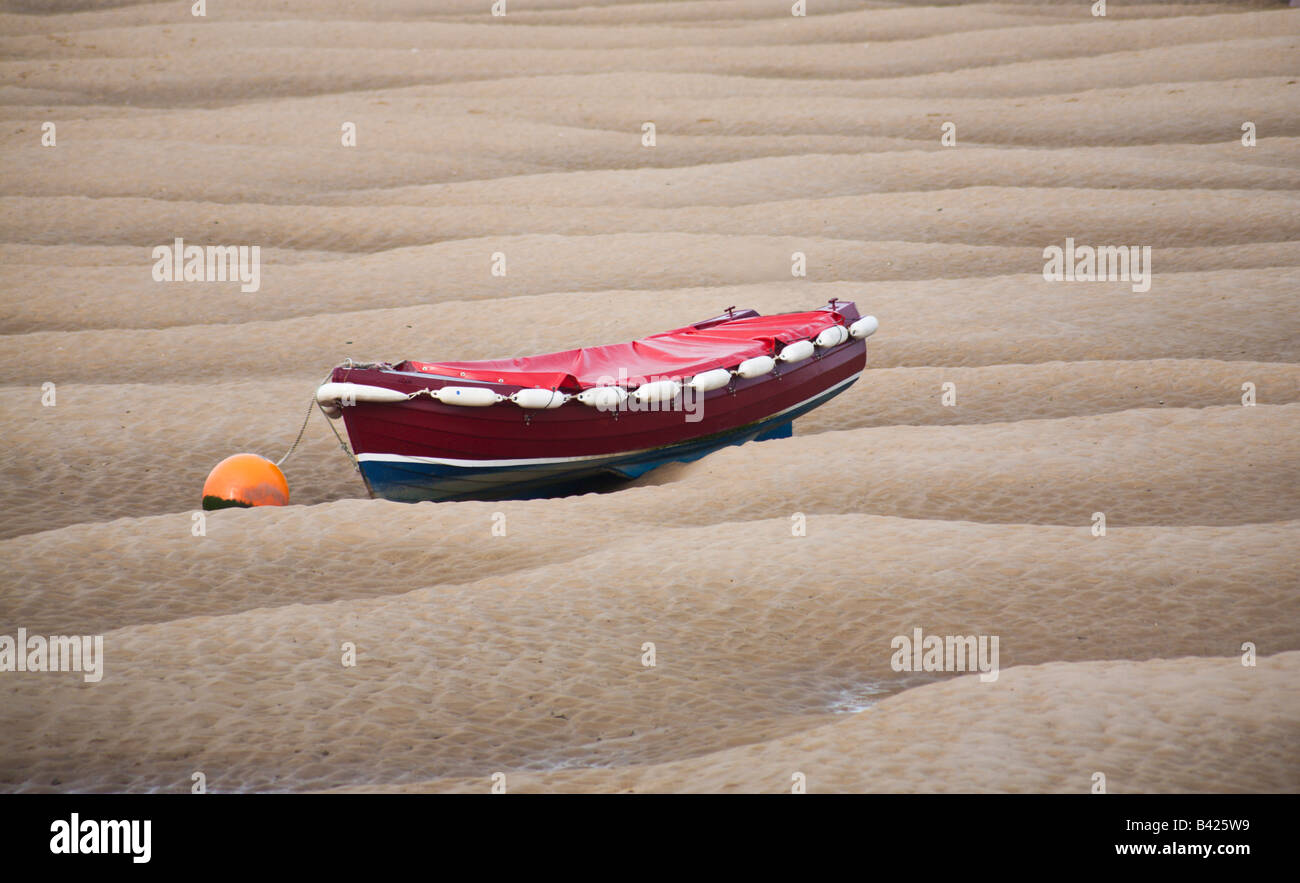 Leuchtend rot Boot auf Sand am nächsten Brunnen Meer Norfolk England UK Stockfoto