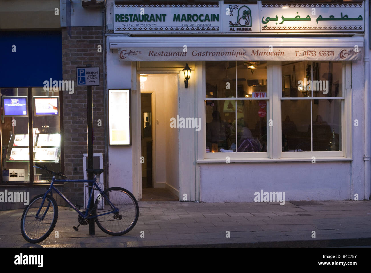 Morocain marokkanische Restaurant In Windsor in der Nacht mit dem Fahrrad angekettet an Straßenschild Stockfoto