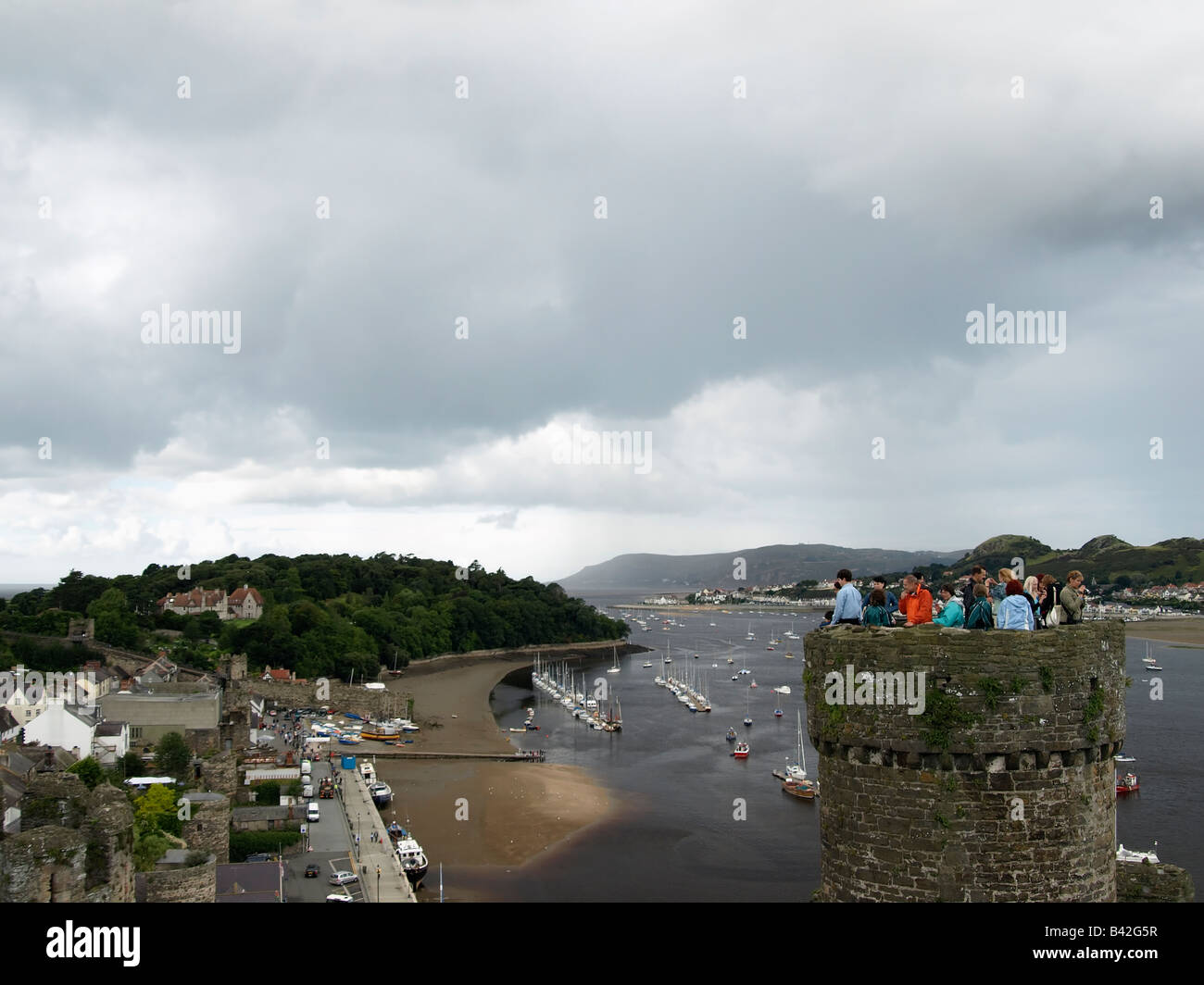 Der Turm ist voller Touristen. Conwy Castle mit dem Hafen im Hintergrund. Conwy ist ein Weltkulturerbe Stockfoto