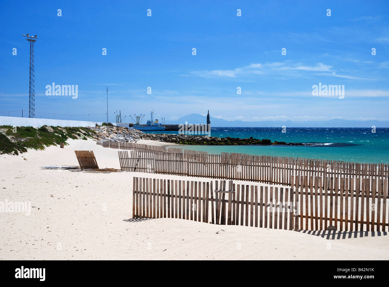 Sand Strand von Tarifa mit Holzzäunen Sand gegen blauen Himmel und türkisblauem Meer Stockfoto