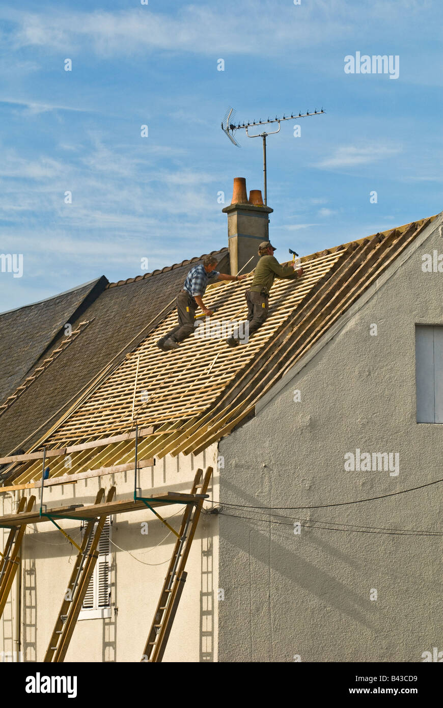 Bauarbeiter arbeiten auf Hausdach, Frankreich. Stockfoto