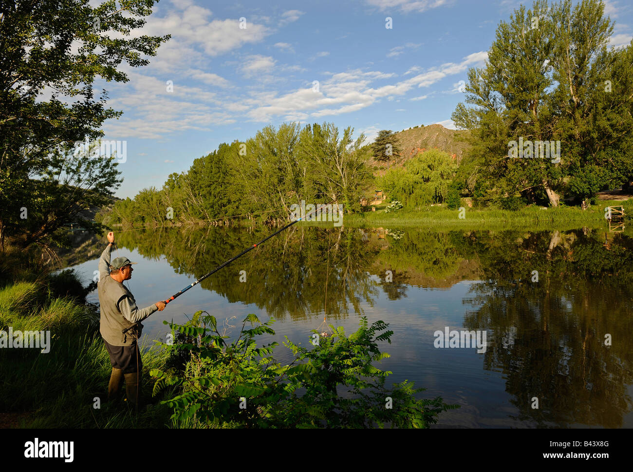 Ein Mann wirft sein Netz wie er nach Krebsen am Fluss Duero in der Stadt Soria Spanien angelt Stockfoto