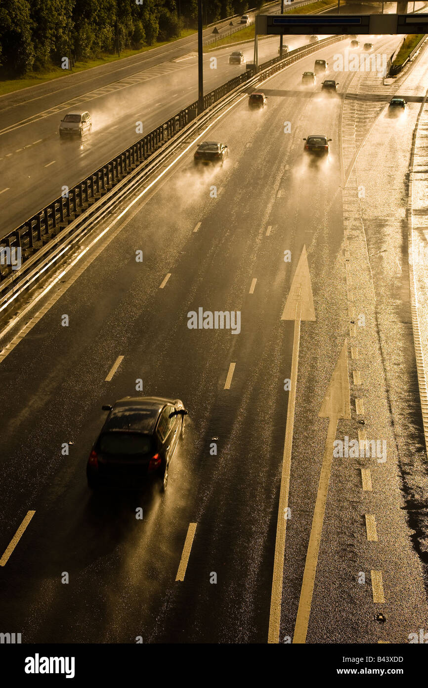Verkehr Beschleunigung auf der Autobahn bei starkem Regen und die Autos sind Erstellen von Spray, M8, Glasgow, Schottland, Großbritannien Stockfoto