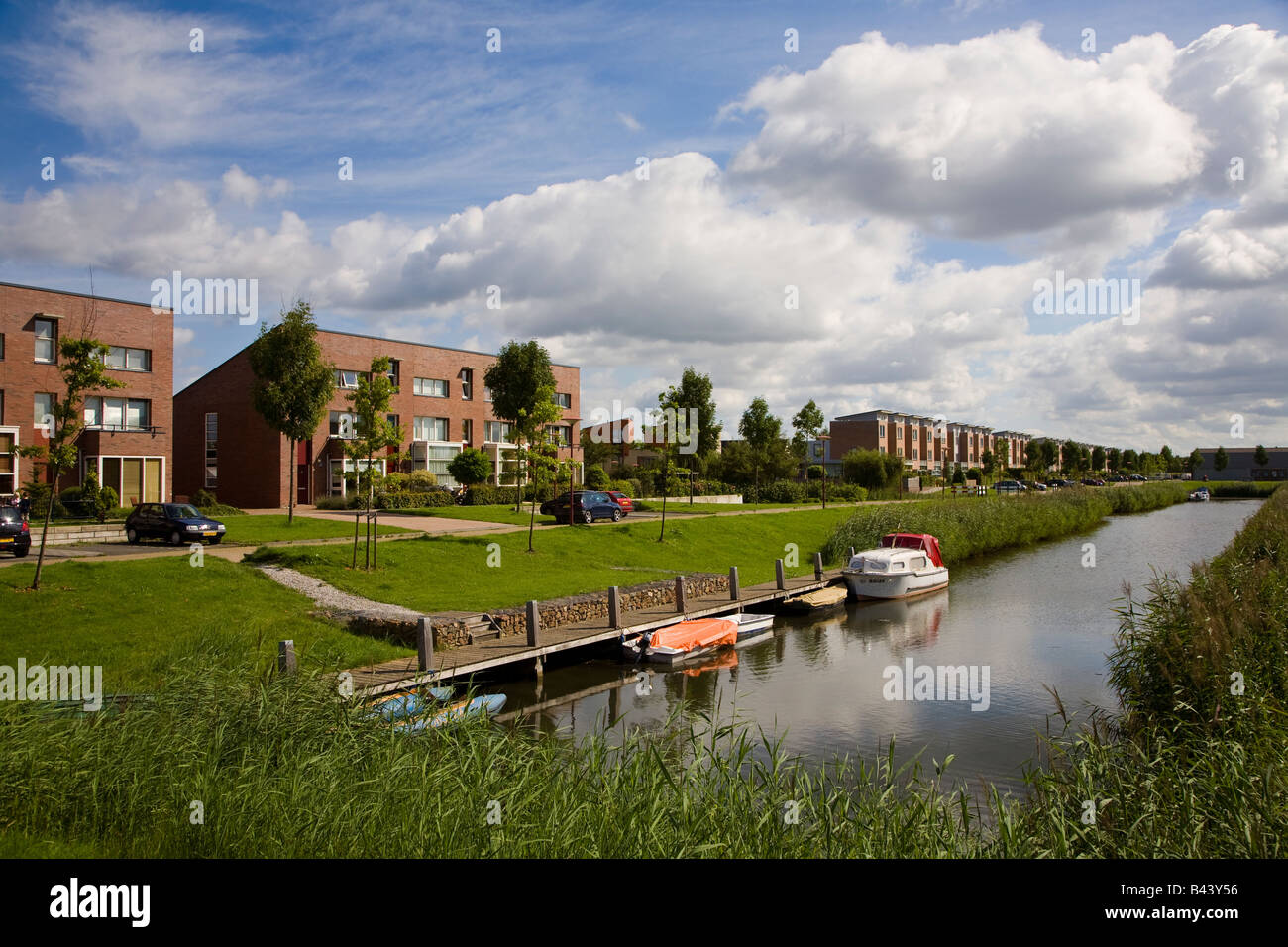 Moderne Häuser auf Neubausiedlung mit Booten auf Kanal Lelystad Niederlande Stockfoto