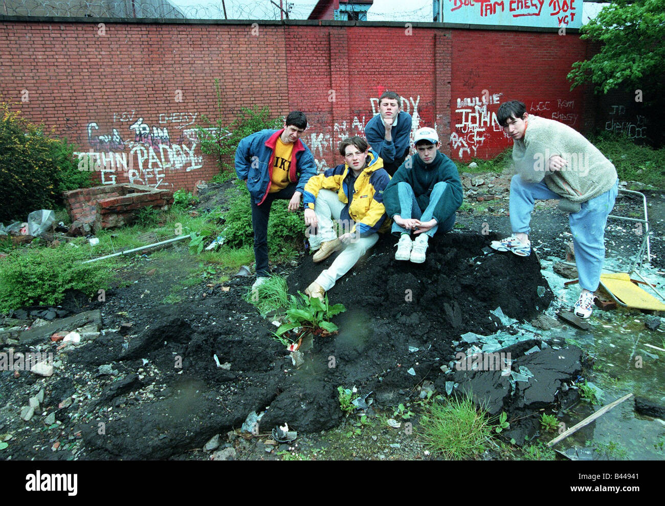 Bandenkriege Govan Mai 1998 im Teenageralter von Haufen von Schutt Wänden sitzen in Graffiti bedeckt Stockfoto