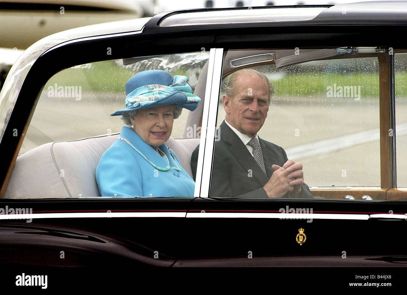 Königin Elizabeth II Mai 2002 Glasgow Airport begleitet von Prinz Philip Duke of Edinburgh tragen blaue Mütze und Mantel Stockfoto