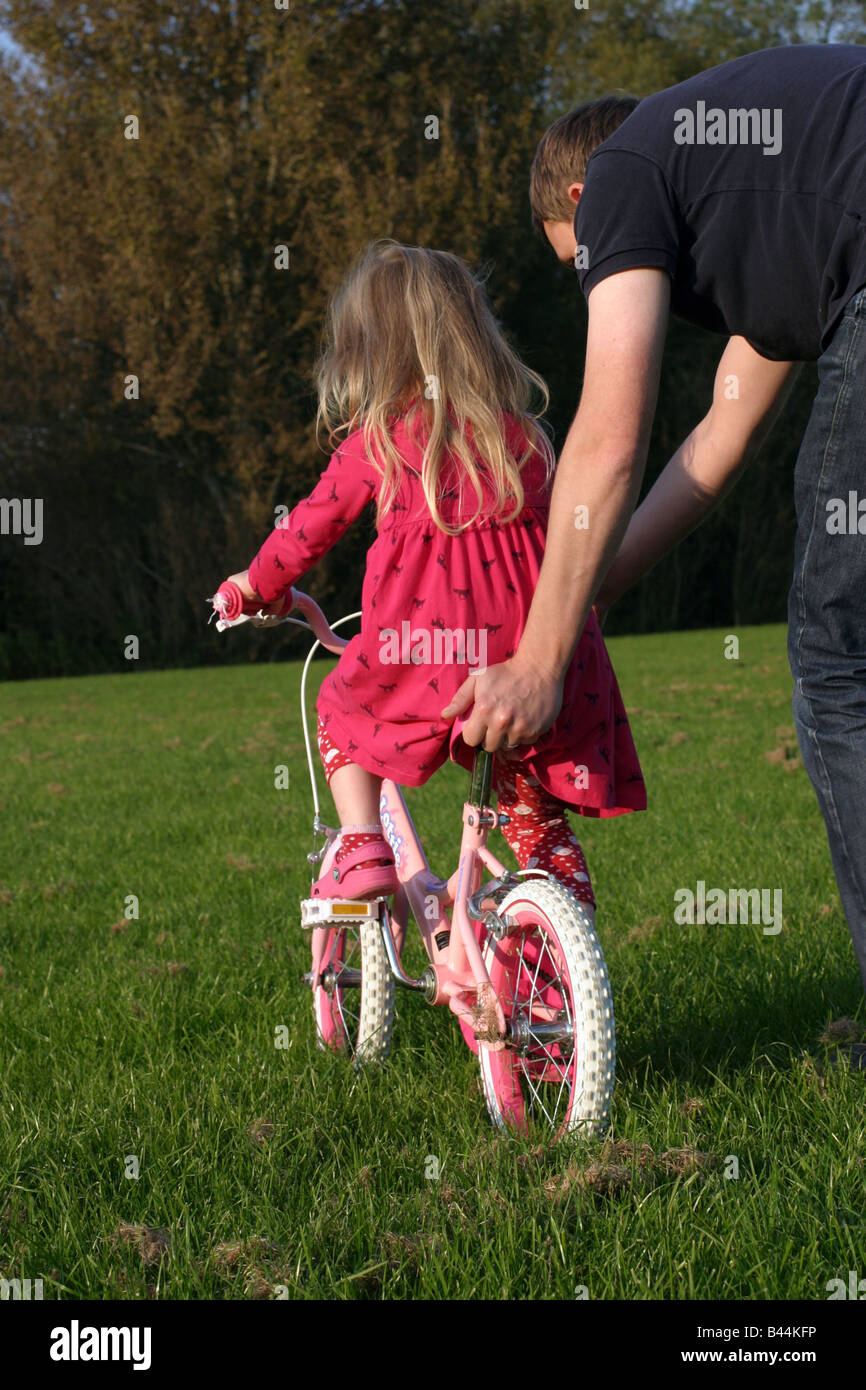 Vater Lehre 4 Jahres altes Mädchen, mit dem Fahrrad Stockfoto