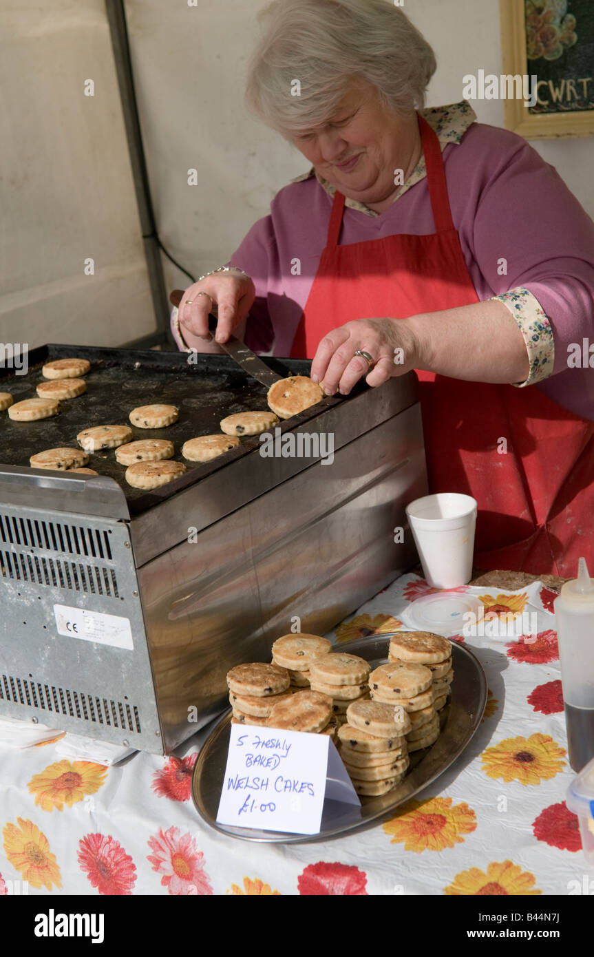 Frau hausgemachte Welsh Cakes Drop Scones auf Grillplatte Heizplatte in Aberystwyth Farmers Market und Essen kochen fair Wales UK Stockfoto