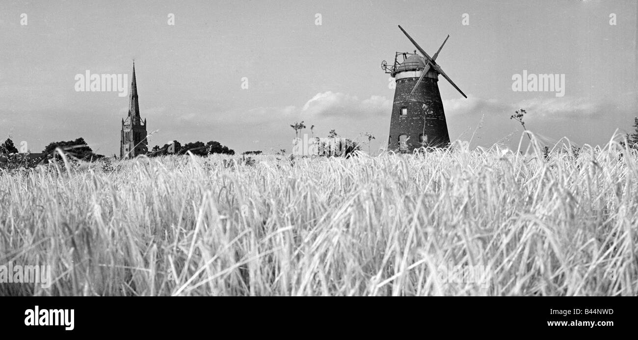 Handfesseln, Kirche und Windmühle umgeben von reifen Weizen ländlichen Religion Kirche Landwirtschaft Getreide Weizen Landschaft Landwirtschaft Stockfoto