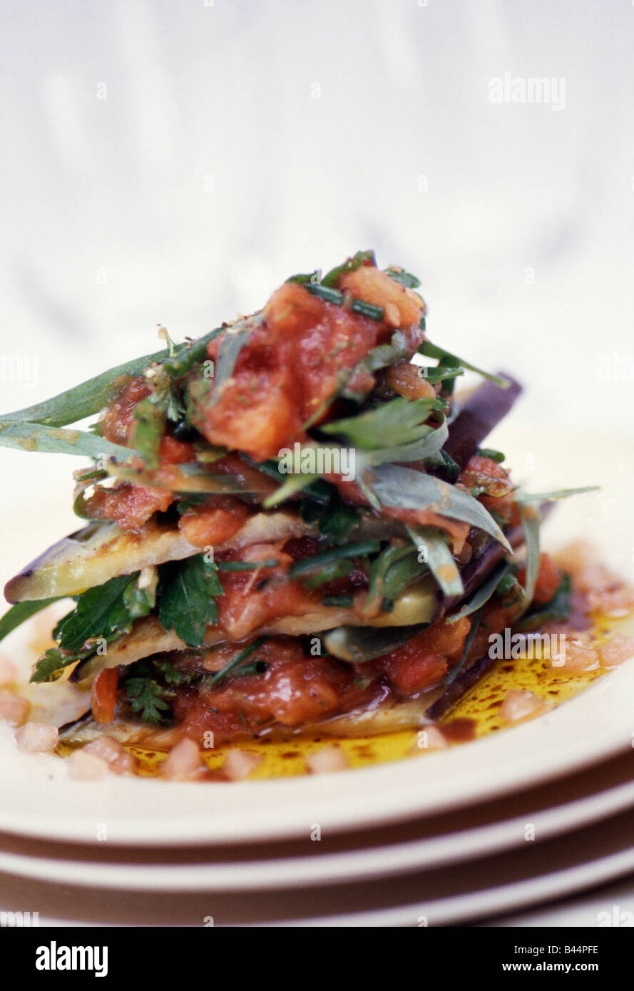 Aubergine Mille-Feuille mit zerdrückten Tomaten und frischen Kräutern Stockfoto