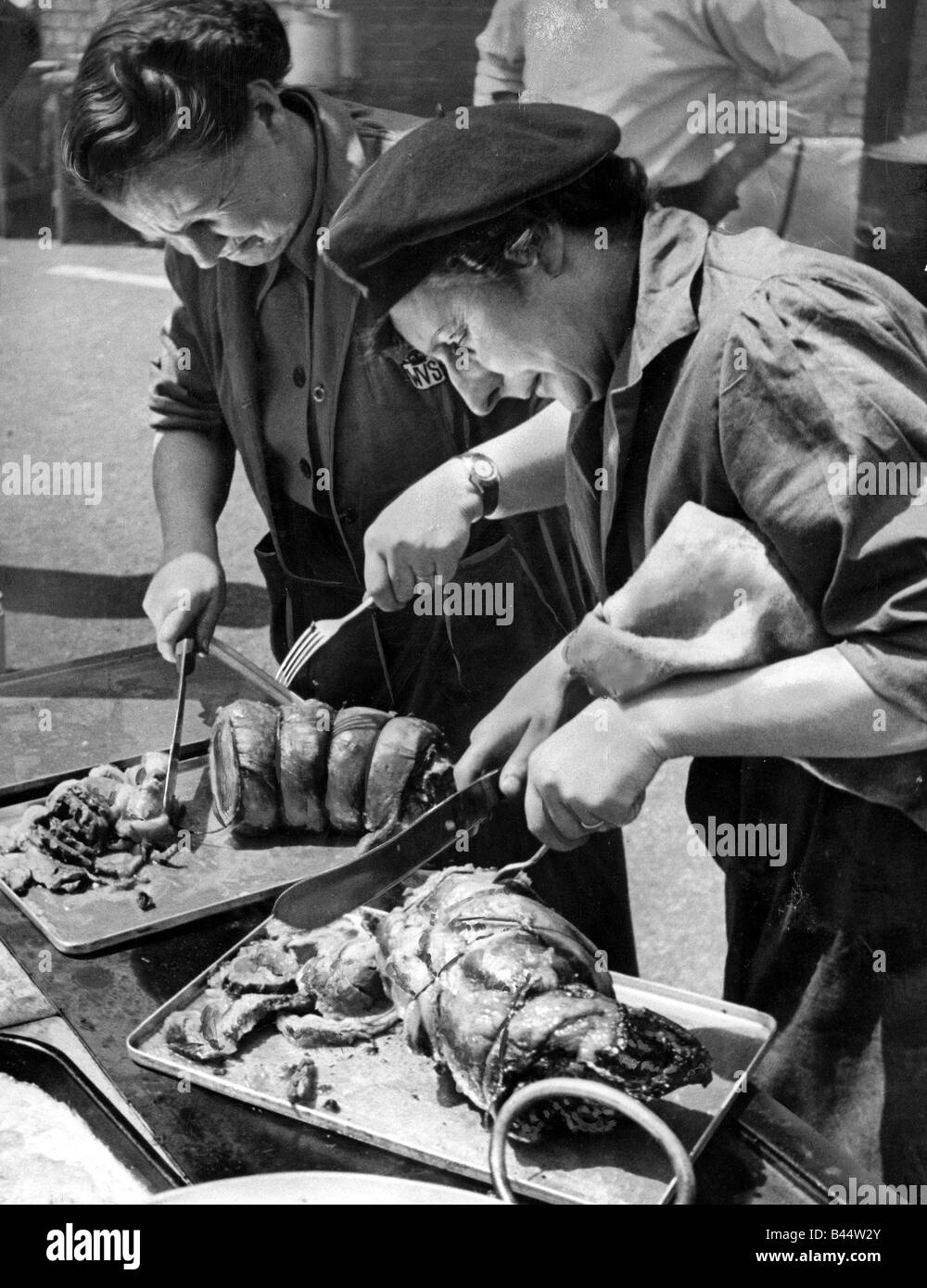 Mitglieder des Freiwilligendienstes Womens schnitzen eine Fuge von Fleisch an Old Montague Street School Dinner für 120 vorbereiten Stockfoto