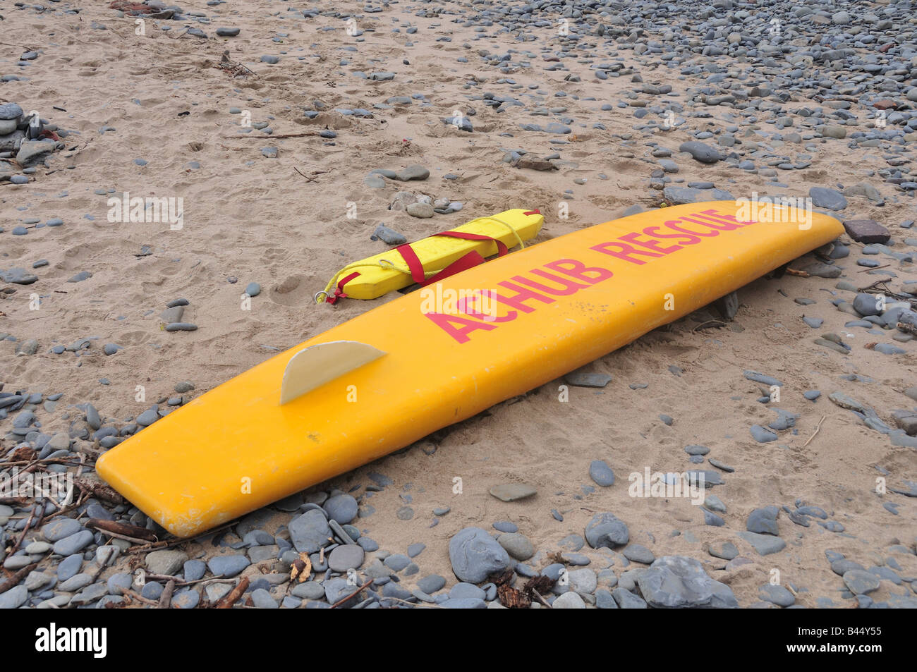 Rettungsschwimmer Surfbrett an einem Strand mit Zeichen in Walisisch und Englisch Llangrannog Strand Ceredigion Wales Stockfoto
