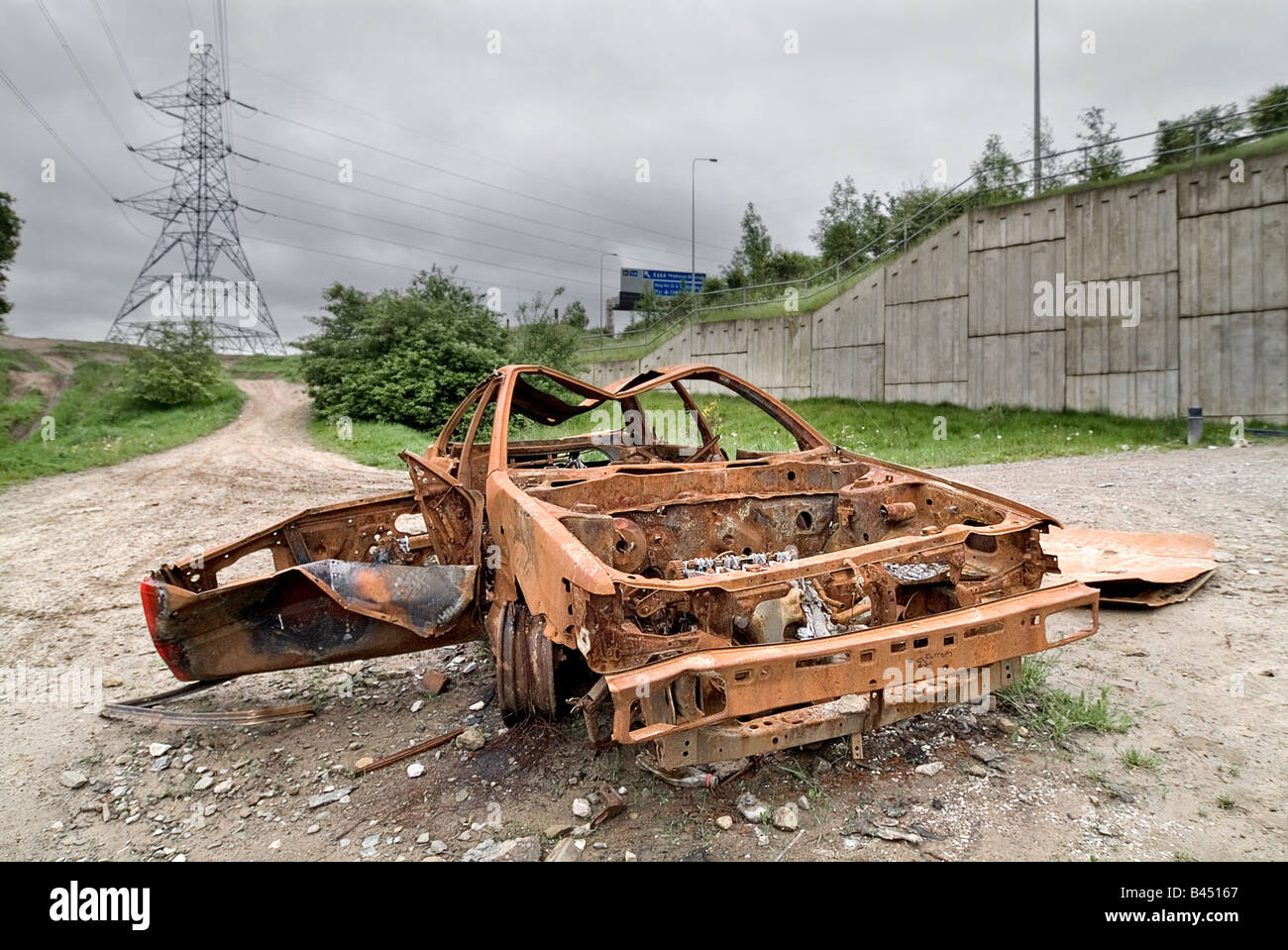 Ohne Zustimmung der Eigentümer Auto unter der Autobahn M60 in Greater Manchester ausgebrannt genommen. Stockfoto