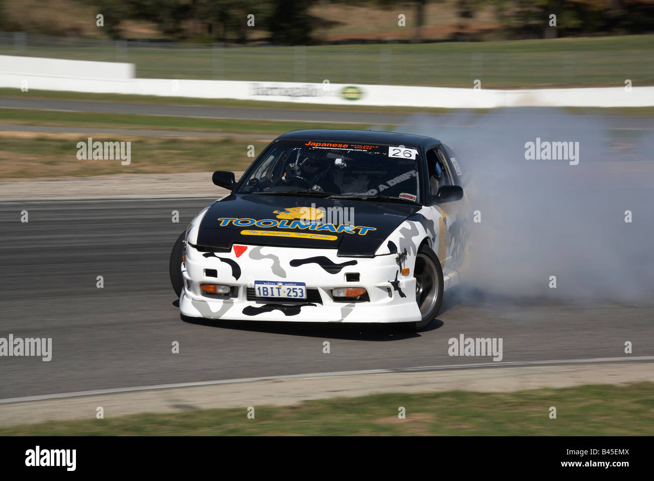 Ein australischer Drift Motorsport Wettbewerber schiebt seinen Nissan 180SX Sportwagen komplett seitlich durch eine Ecke Stockfoto