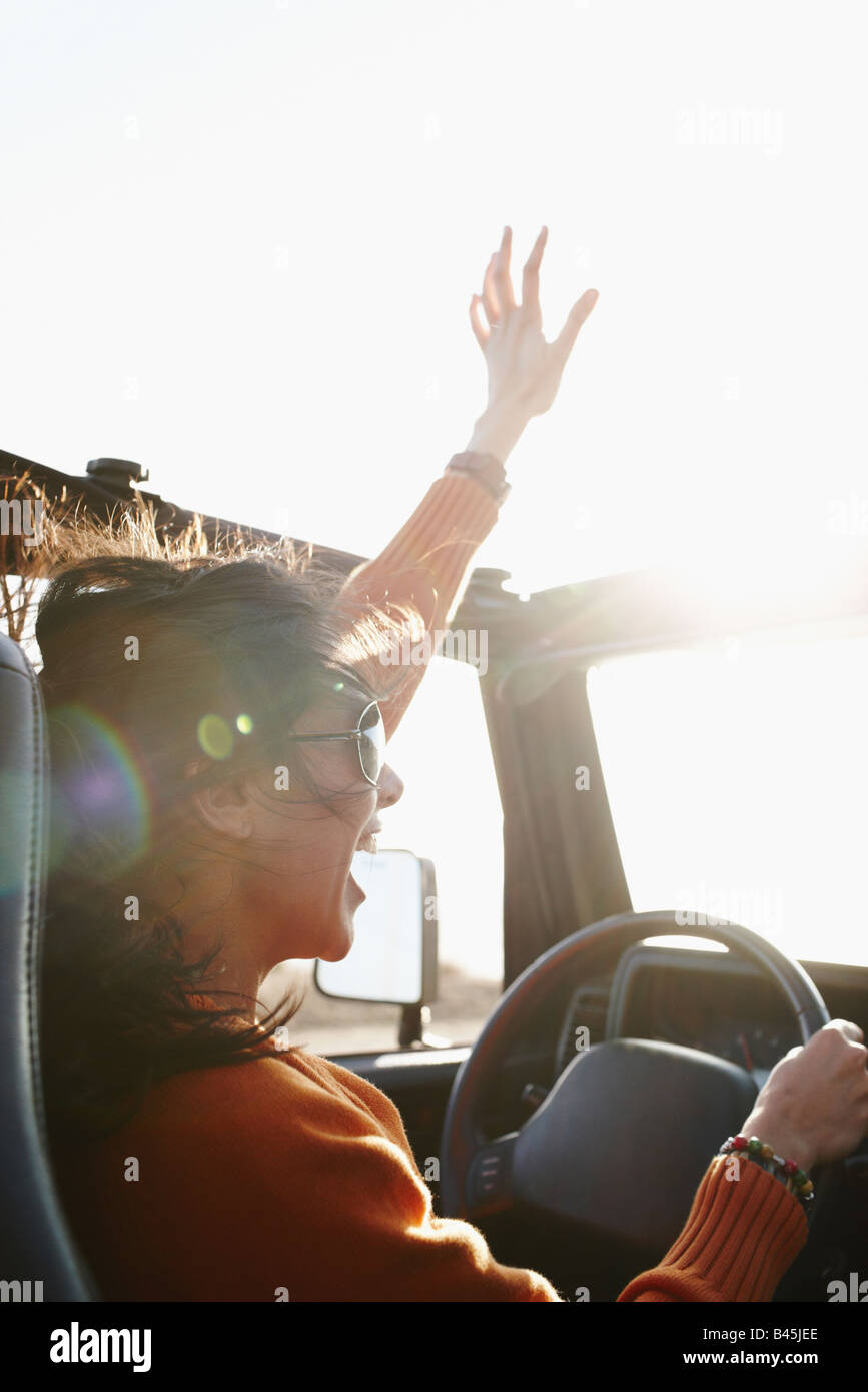Hispanic Frau heben die Arme während der Fahrt Stockfoto