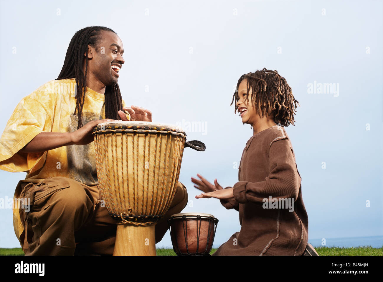 Afrikanischen Vater und Sohn Schlagzeug spielen Stockfoto