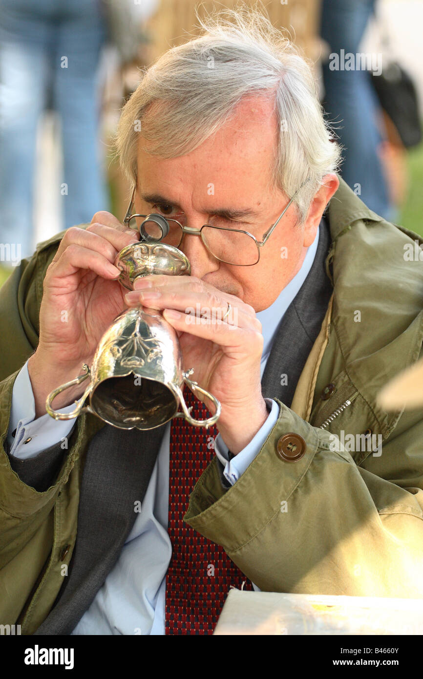 BBC TV The Antiques Roadshow Experte prüft genau, silbernen Pokal mit seinem Auge Stück Vergrößerung Glas Stockfoto