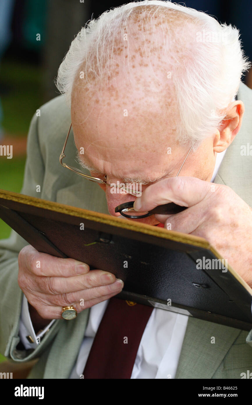 BBC TV The Antiques Roadshow Experte prüft genau, ein altes Foto mit seinem Auge Stück Vergrößerung Glas genommen Herbst 2008 Stockfoto