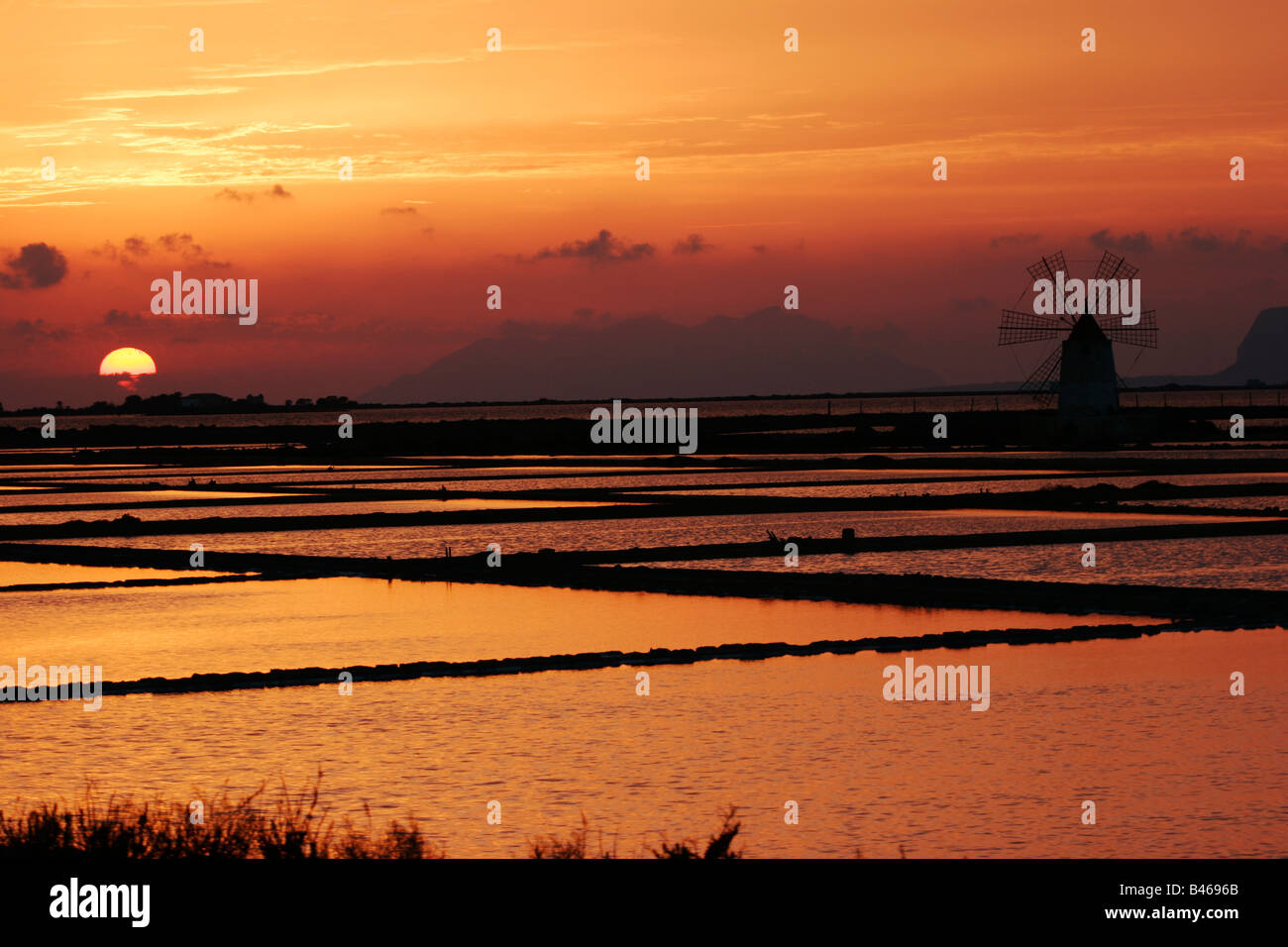 Abendrot auf Windmühlen verwendet, Meersalz in die Lagune Stagnone zu produzieren durch Insel Mozia, Marsala, Trapani Sizilien Stockfoto