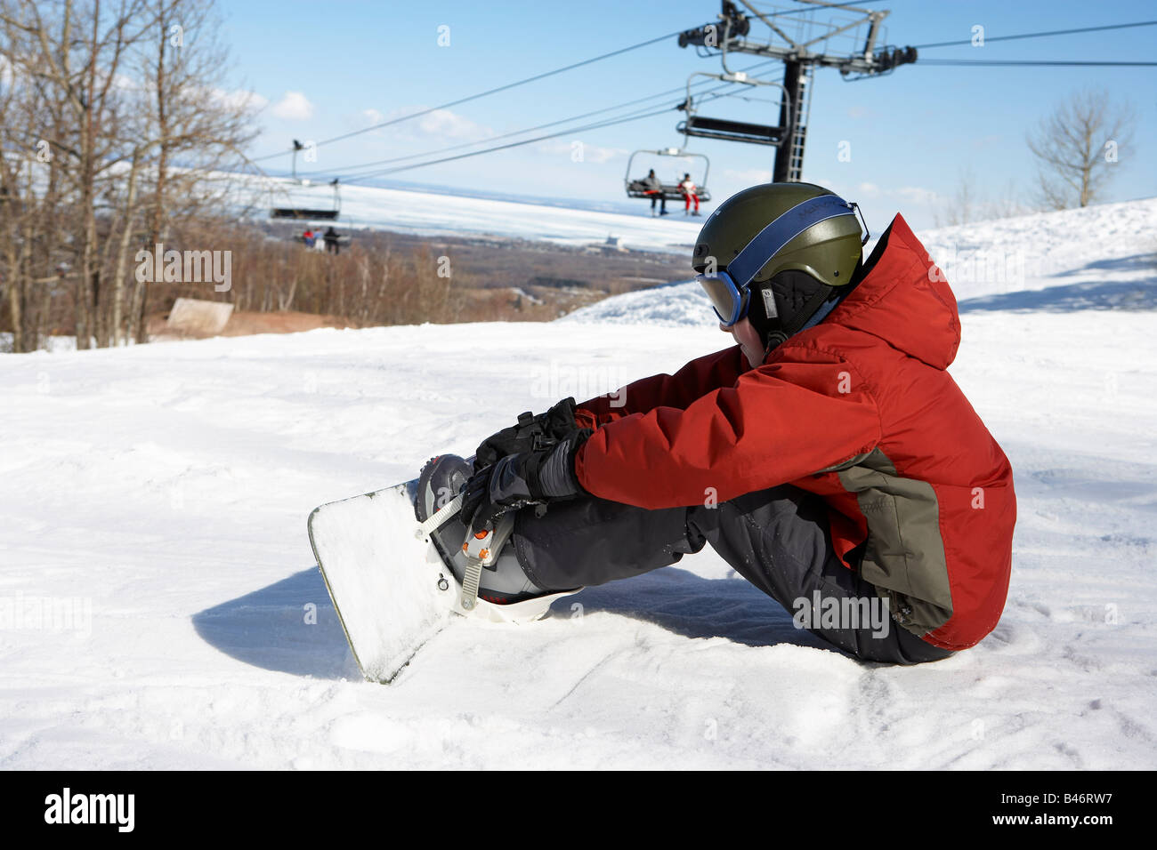 Boy am Ski-Hügel mit Snowboard, Blue Mountain, Collingwood, Ontario, Kanada Stockfoto